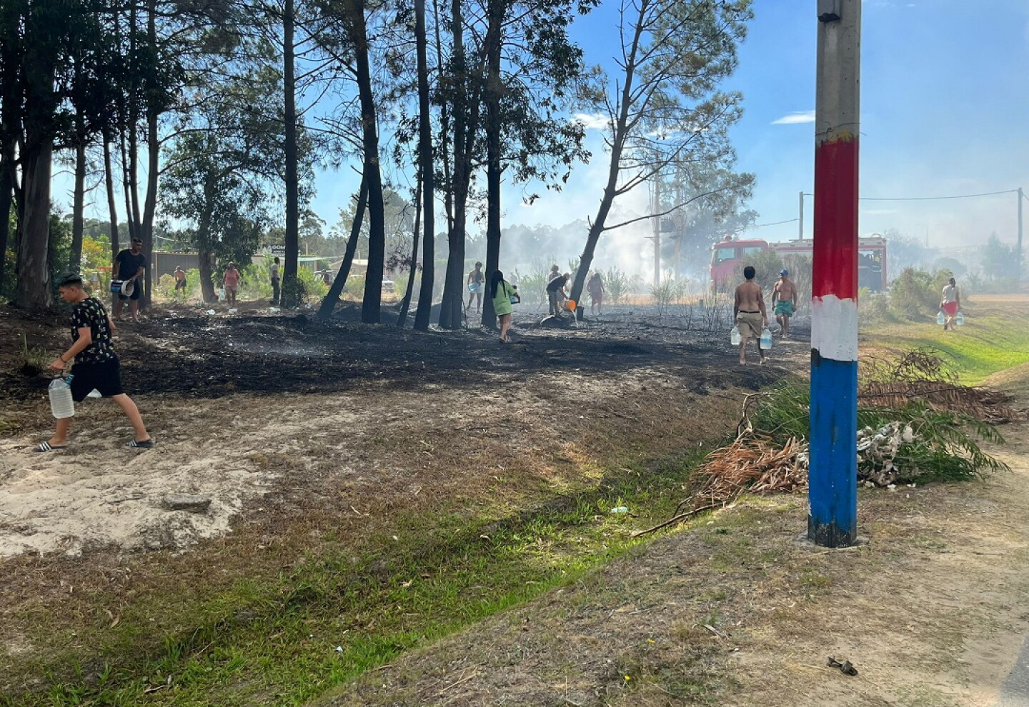 Vecinos combaten incendio en La Floresta con bidones de agua.