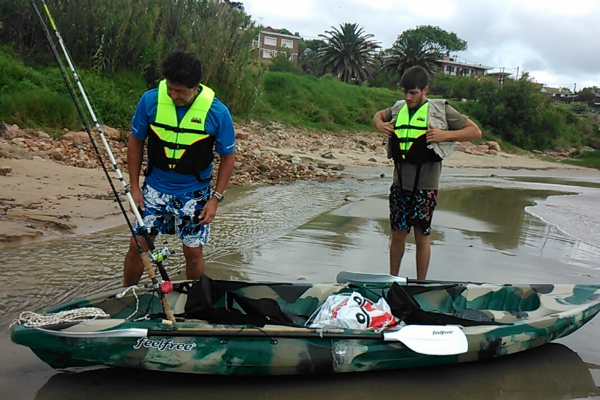 Padre e hijo preparándose para una jornada de pesca en kayak.