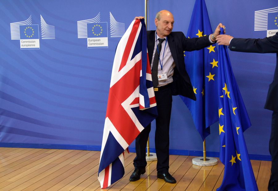 El pabellón británico es retirado por funcionario en la sede de la UE. Foto: AFP