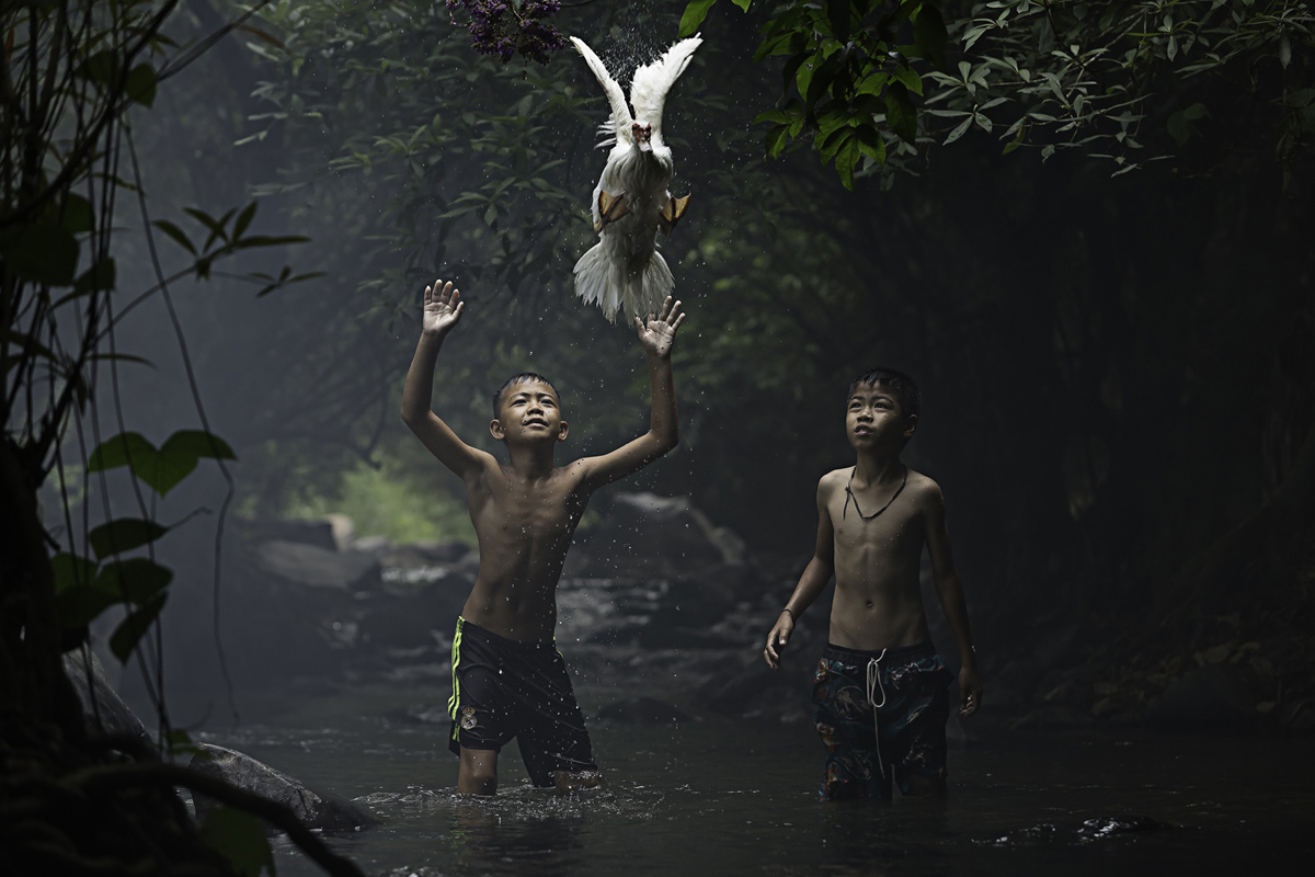 Mención: Dos niños intentan atrapar un pato en la provincia de Nong Khai, Tailandia. Foto: Sarah Wouters.