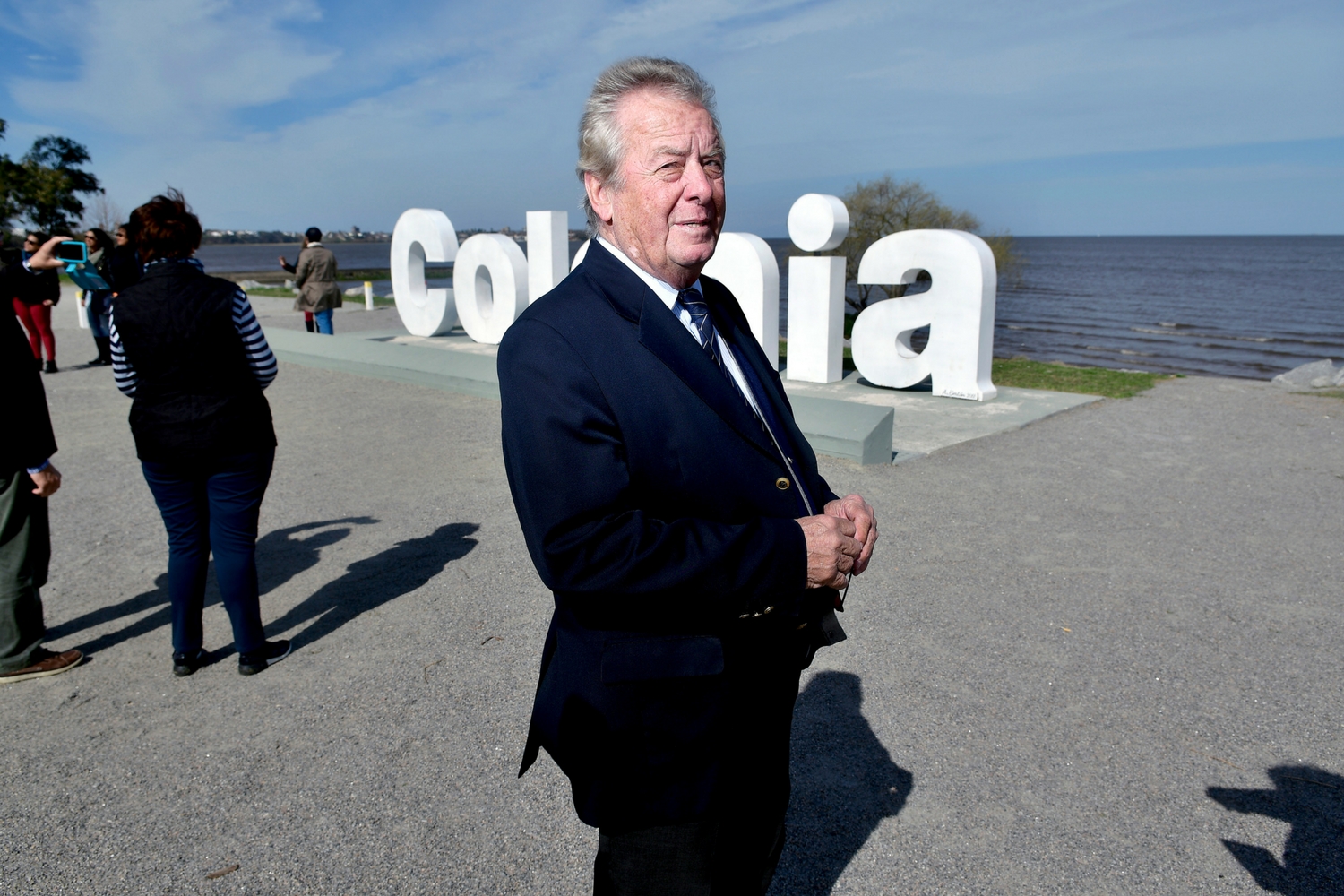 El intendente de Colonia Carlos Moreira frente al cartel ubicado en la rambla, una de las postales de la ciudad.