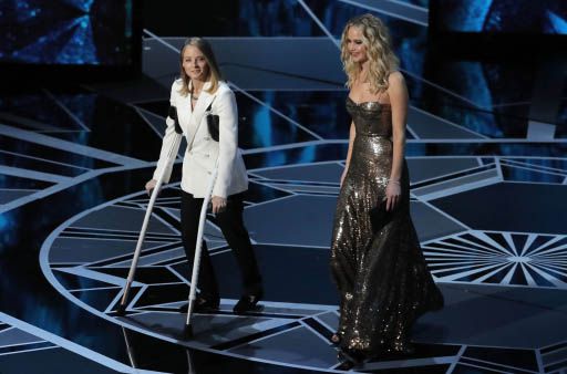 Jodie Foster en muletas y Jennifer Lawrence en la previa a entregar el Oscar a la Mejor Actriz. Foto: Reuters