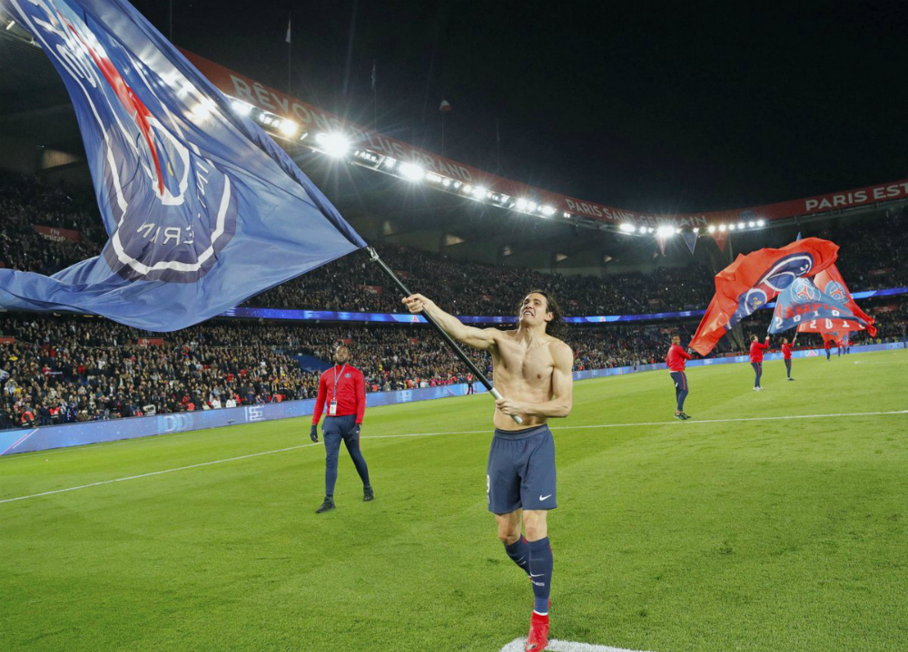 Edinson Cavani haciendo flamear la bandera del PSG en la cancha