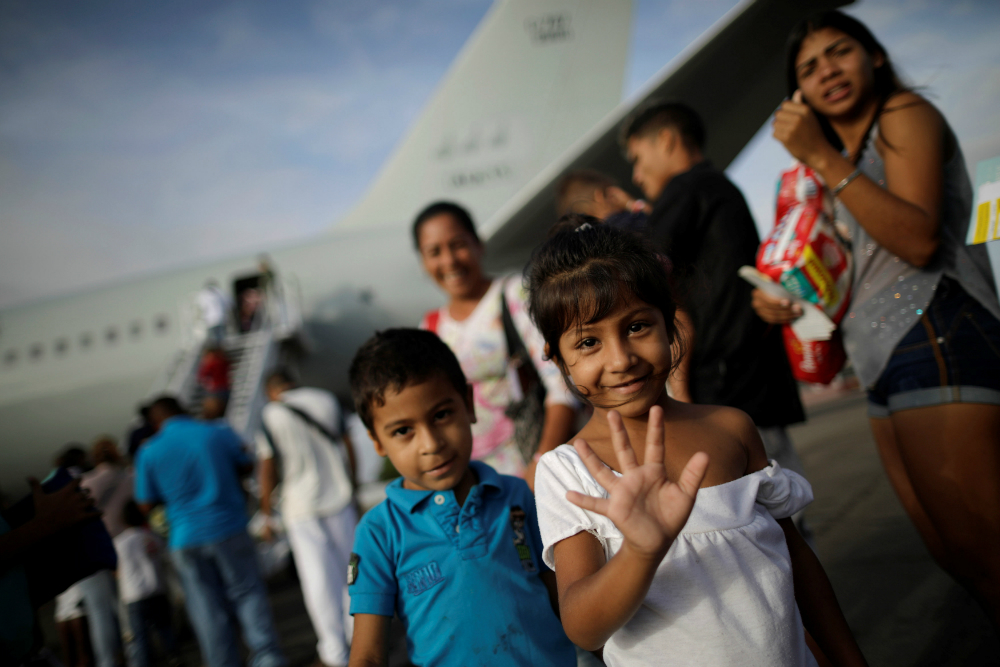 Una niña venezolana saluda al abordar un avión de la Fuerza Aérea de Brasil. Foto: Reuters