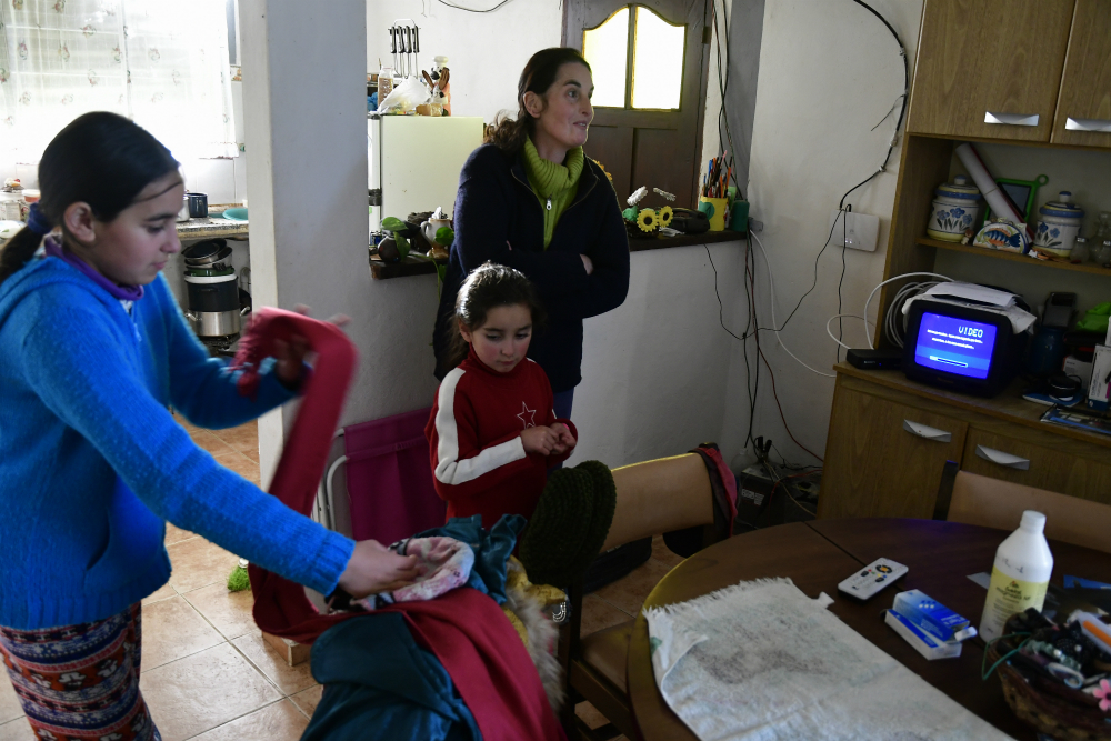 En familia: María Torrente y sus hijas en la casa de Los Tapes (Lavalleja). La tele a 12 voltios la alimentan con paneles y dura dos horas. Foto: Fernando Ponzetto.