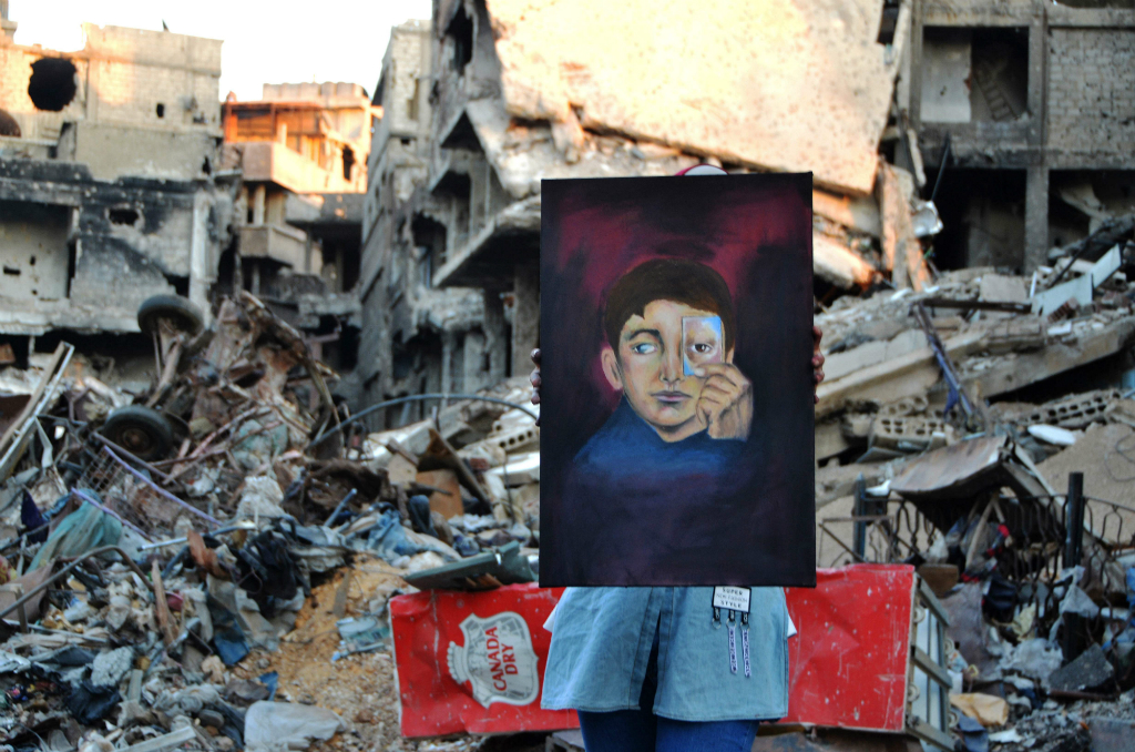 En medio de edificios derruidos, los jóvenes pintan con colores y lápices. Foto: AFP