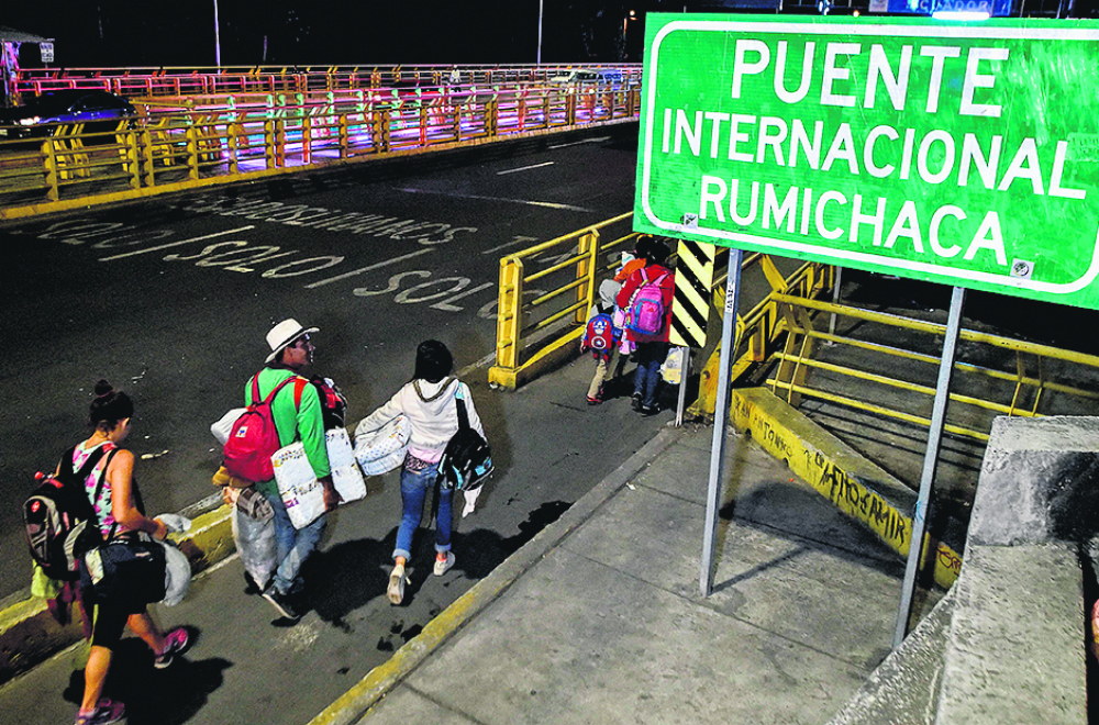 Familias al cruzar el Puente Internacional Rumichaca, entre Ipiales (Colombia) y Tulcan (Ecuador). Foto: AFP