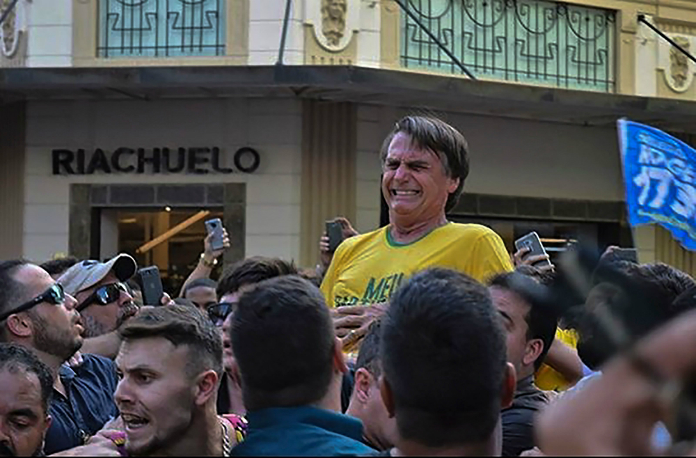 Jair Bolsonaro hace un gesto de dolor al ser apuñalado. Foto: AFP