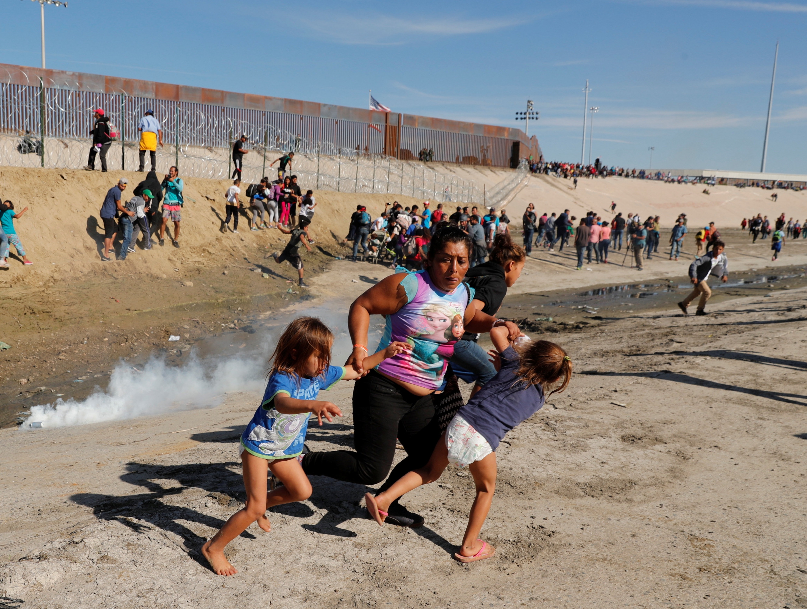 Unos 500 migrantes centroamericanos se lanzaron a cruzar la valla entre Tijuana (México) y San Diego (EE.UU). Guardia fronteriza les lanzó gas lacrimógeno. Foto: Reuters.