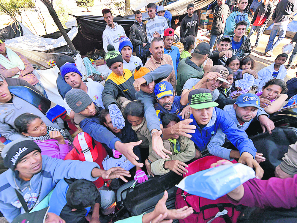 Migrantes venezolanos reciben donaciones en campamento improvisado en Quito. Foto. AFP