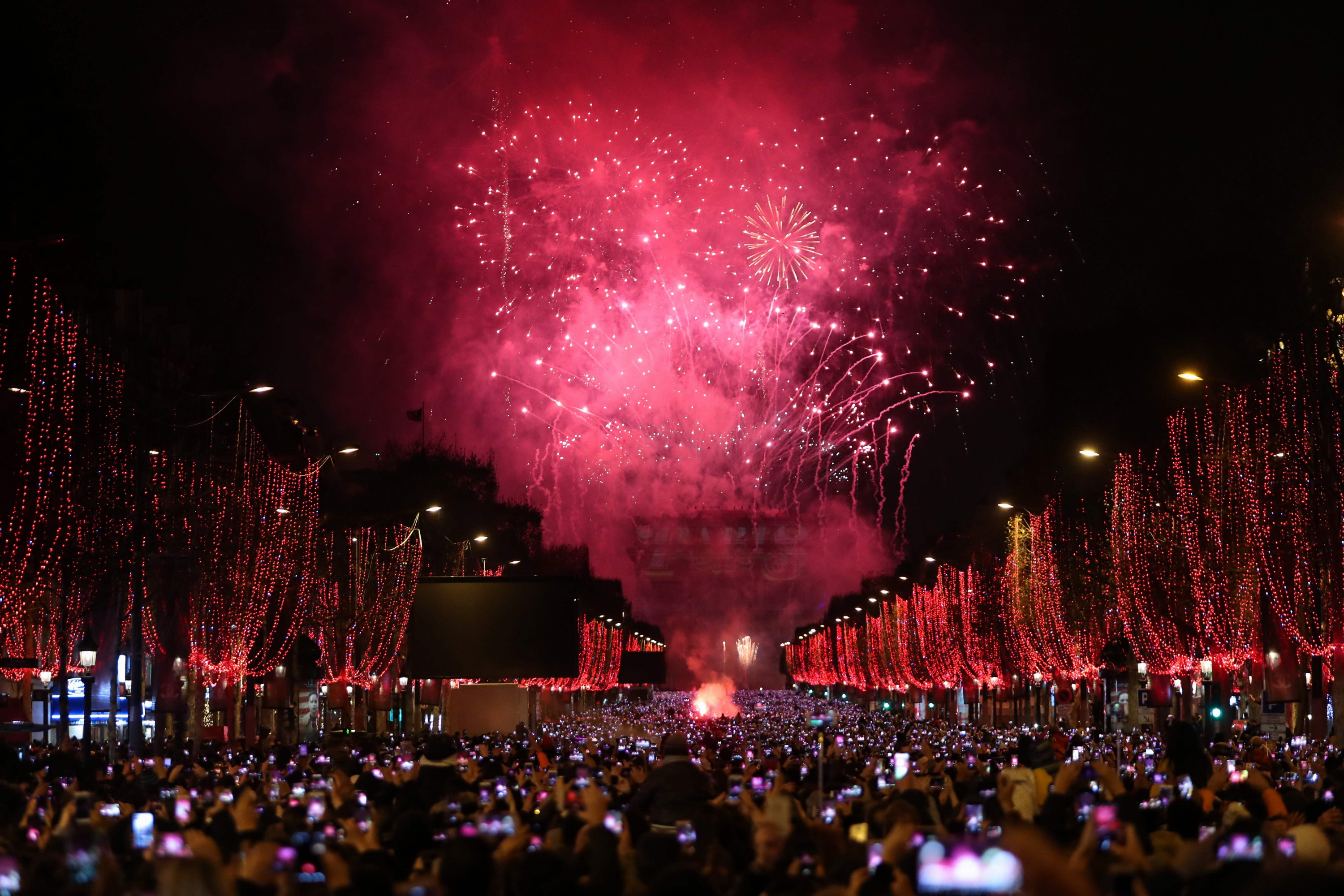 Fuegos artificiales explotan sobre el Arco de Triunfo en Paris. Foto: AFP