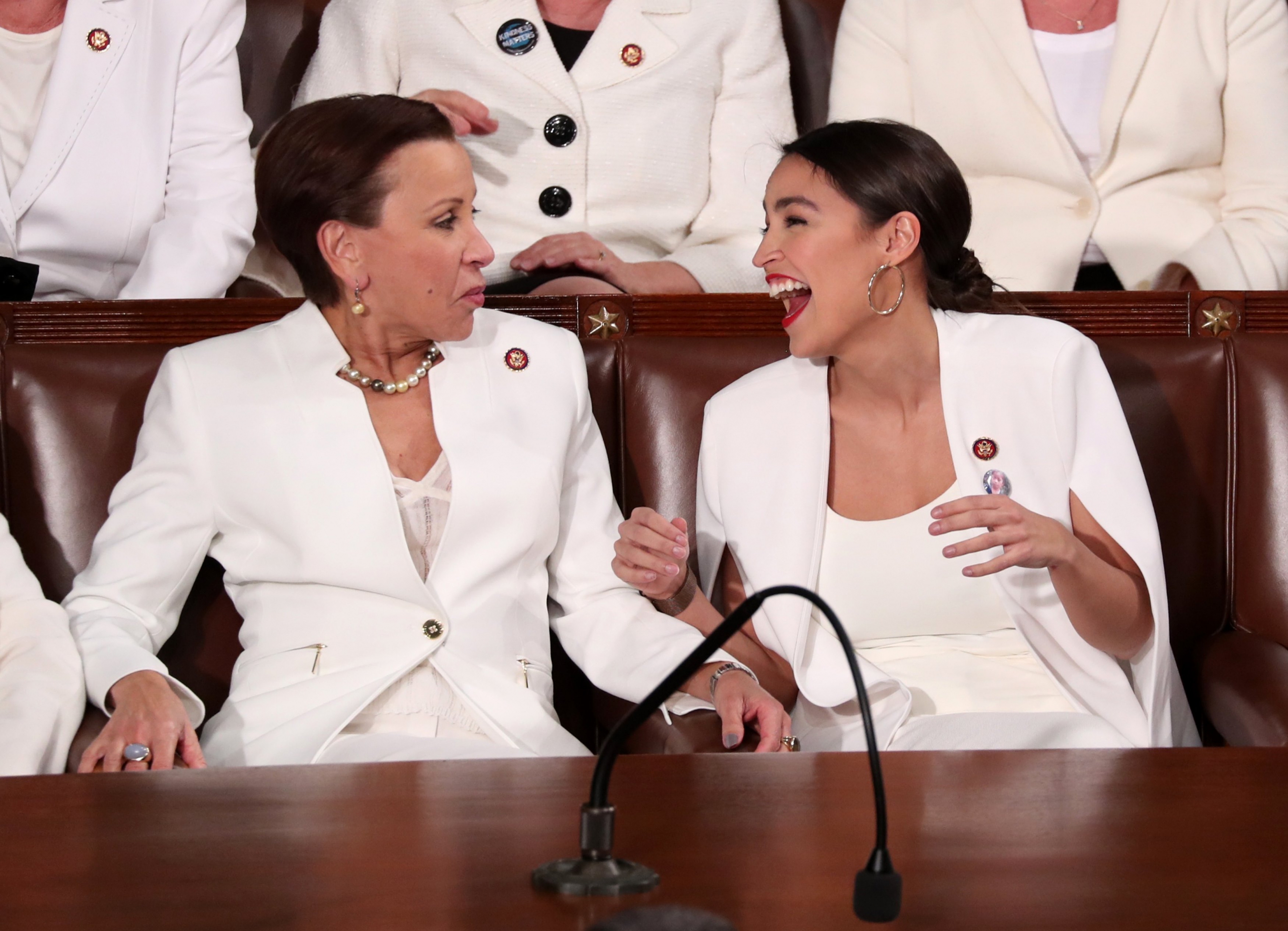 Alexandria Ocasio-Cortez, sonriente, minutos antes que ingrese Trump. Foto: Reuters