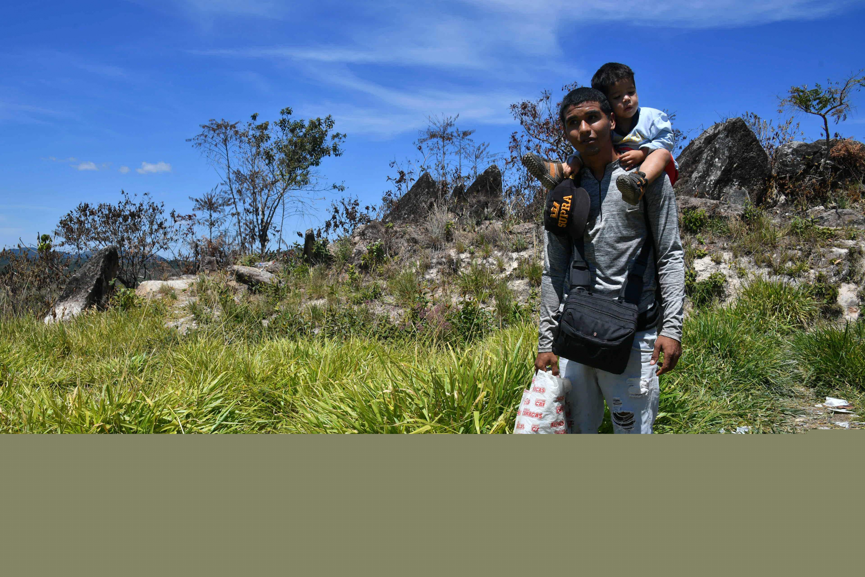 Un policía venezolano junto con su hijo cuando llega a Brasil para buscar refugio. Foto: AFP