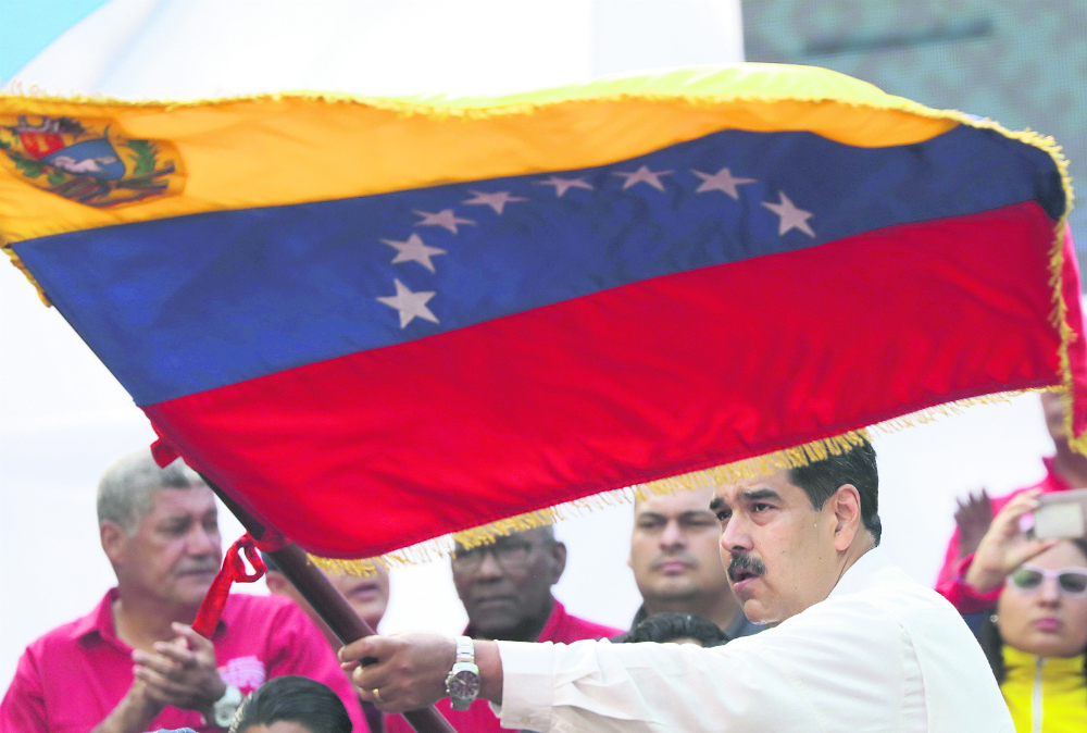 Maduro hace ondear la bandera en el acto realizado ayer. Foto: Reuters
