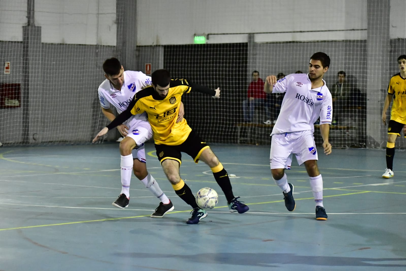 Juan Custodio de Peñarol ante la marca de Rafael Ramos y Joaquín Varietti de Nacional. Foto: Rodrigo Arrillaga