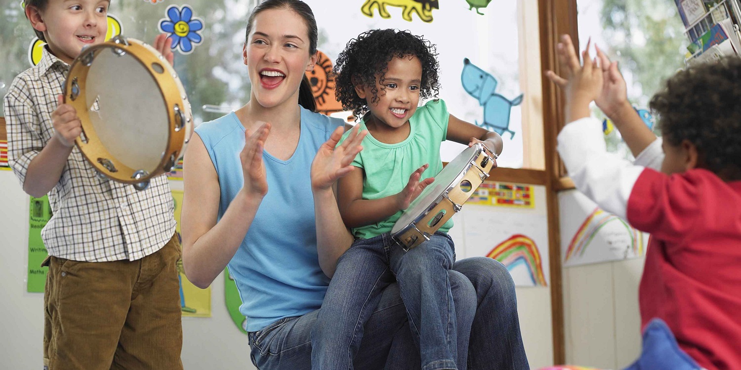 Maestra toca pandereta con niños