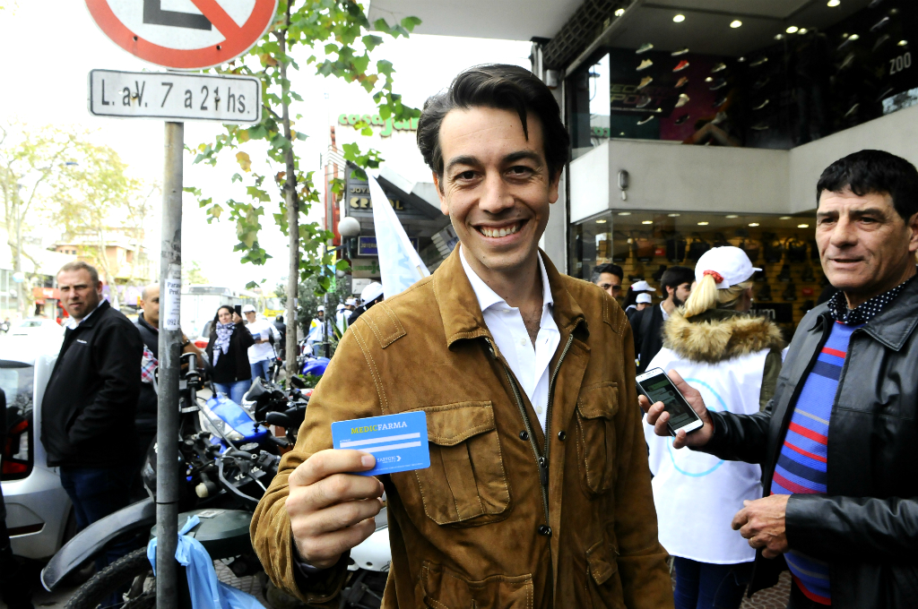 Juan Sartori muestra la tarjeta Medicfarma. Foto: Darwin Borrelli