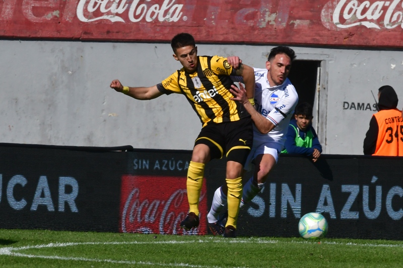Gabriel Rojas ante la marca de Matías Zunino en el clásico entre Nacional y Peñarol. Foto: Gerardo Pérez.