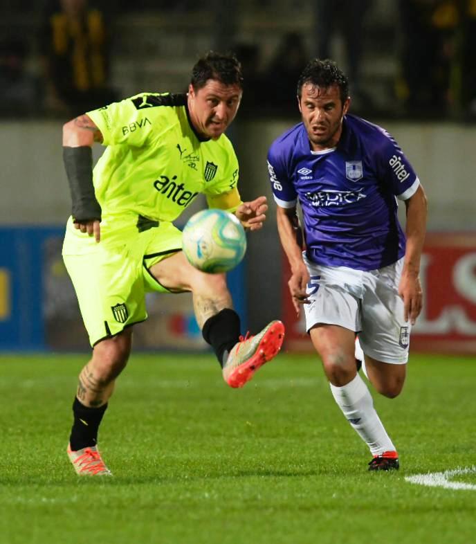 Cristian Rodríguez saca el pase sin que Álvaro González pueda impedirlo. Foto: Gerardo Pérez