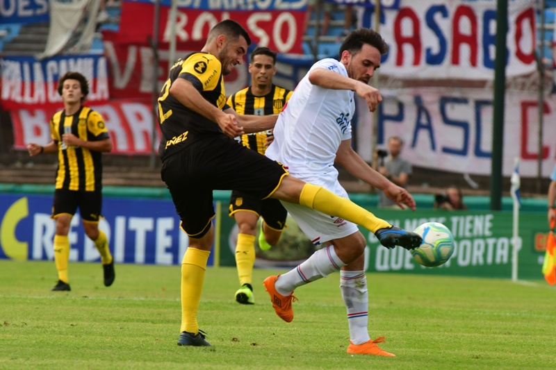 Fabricio Formiliano y Matías Zunino disputan la pelota en el duelo entre Peñarol y Nacional. Foto: Francisco Flores.