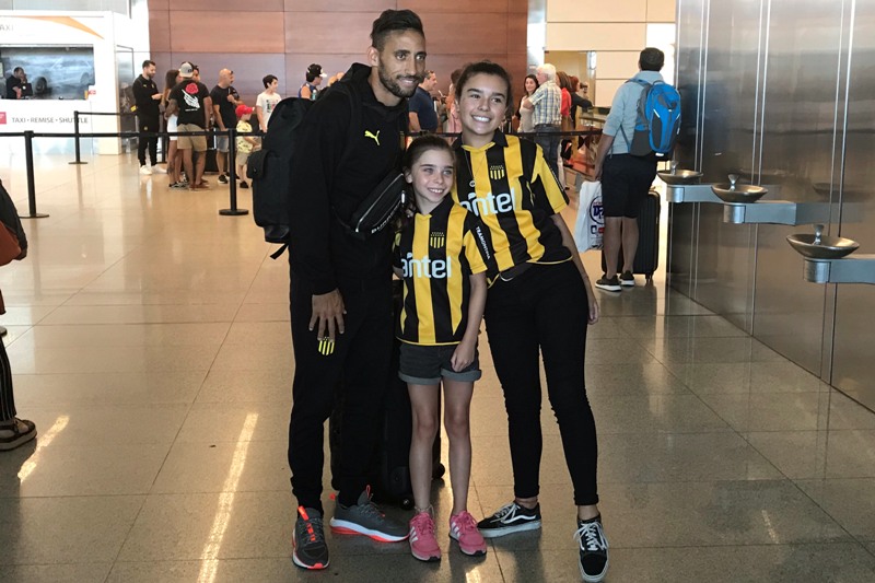Jonathan Urretaviscaya posa con hinchas de Peñarol en el arribo desde Los Ángeles. Foto: Pablo Cupese.