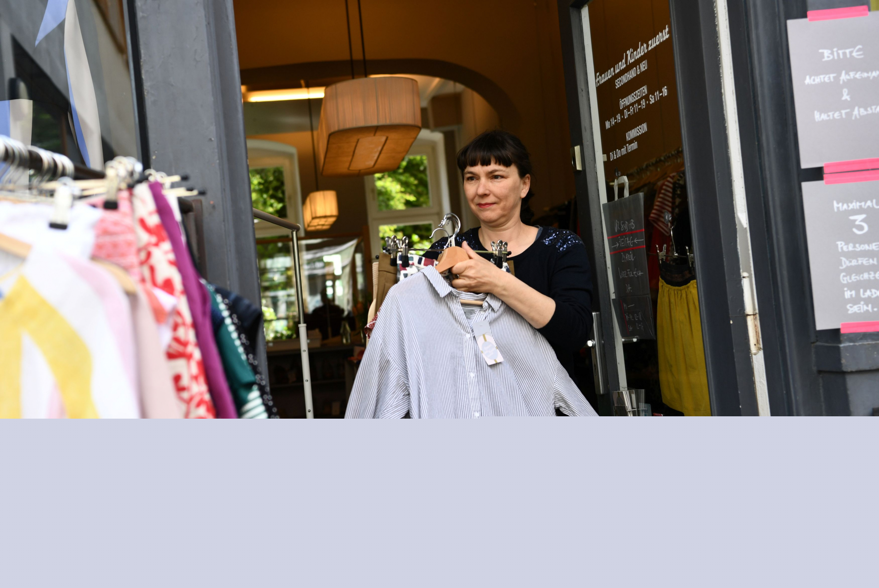 Una vendedora de ropa abre la tienda a medida que se propaga el virus del coronavirus. Foto: Reuters.