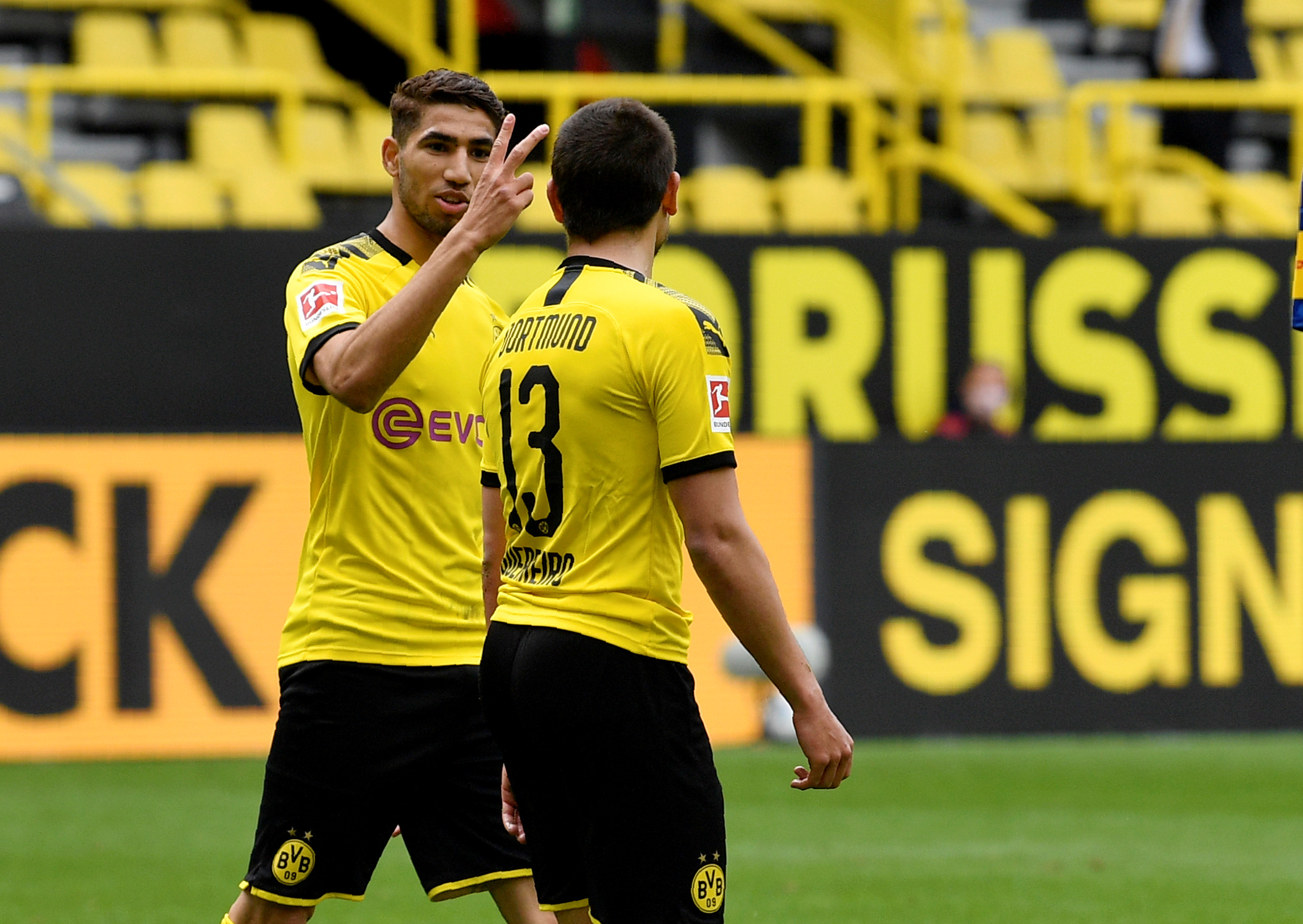 ¿Dos? Sí, dos. Hakimi bromea con Guerreiro por sus dos tantos en el Dortmund-Schalke. Foto: Reuters.