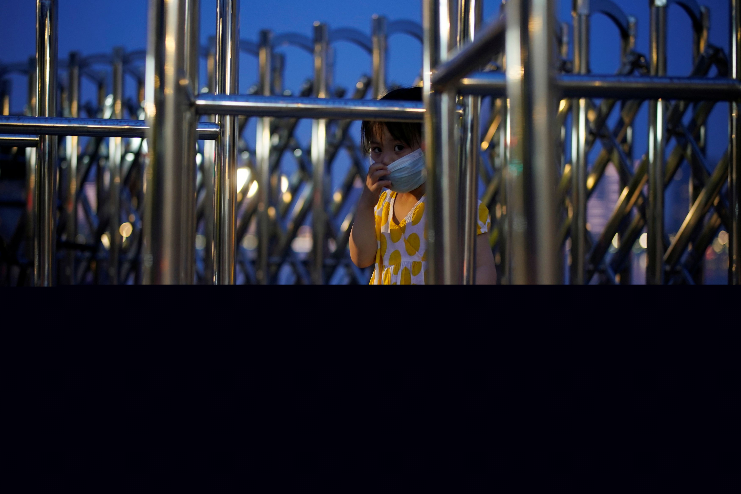 Una niña con un barbijo en un parque en Wuhan. Foto: Reuters.
