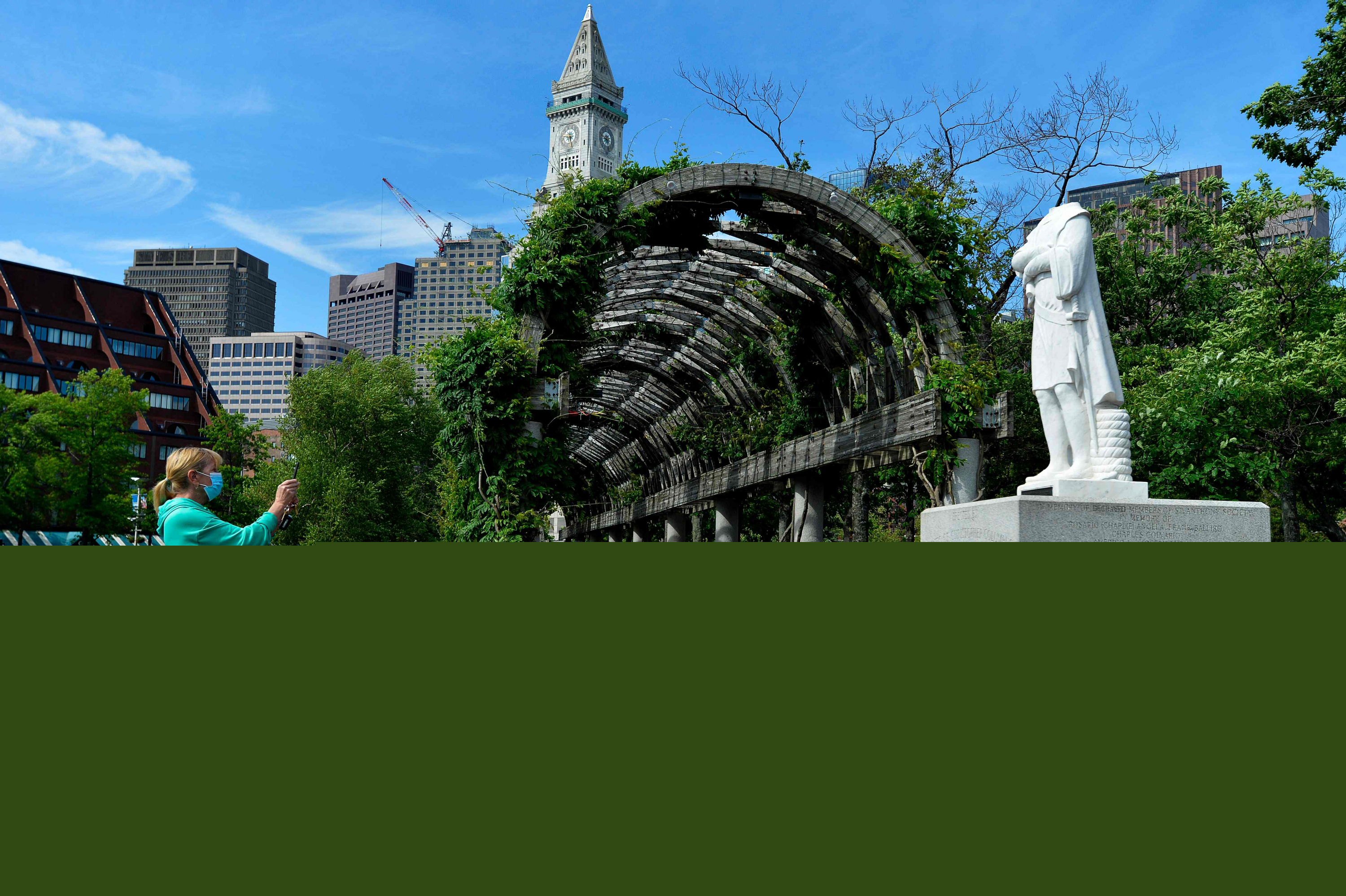 Una mujer toma una foto frente a una estatua decapitada de Cristóbal Colón en Boston. Foto: AFP.