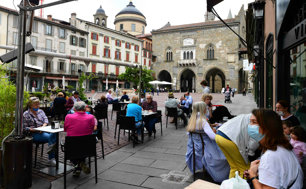 Habitantes de Bergamo vuelven a disfrutar de encuentros al aire libre en la terraza de un café, tras aliviarse las restricciones. Foto: AFP