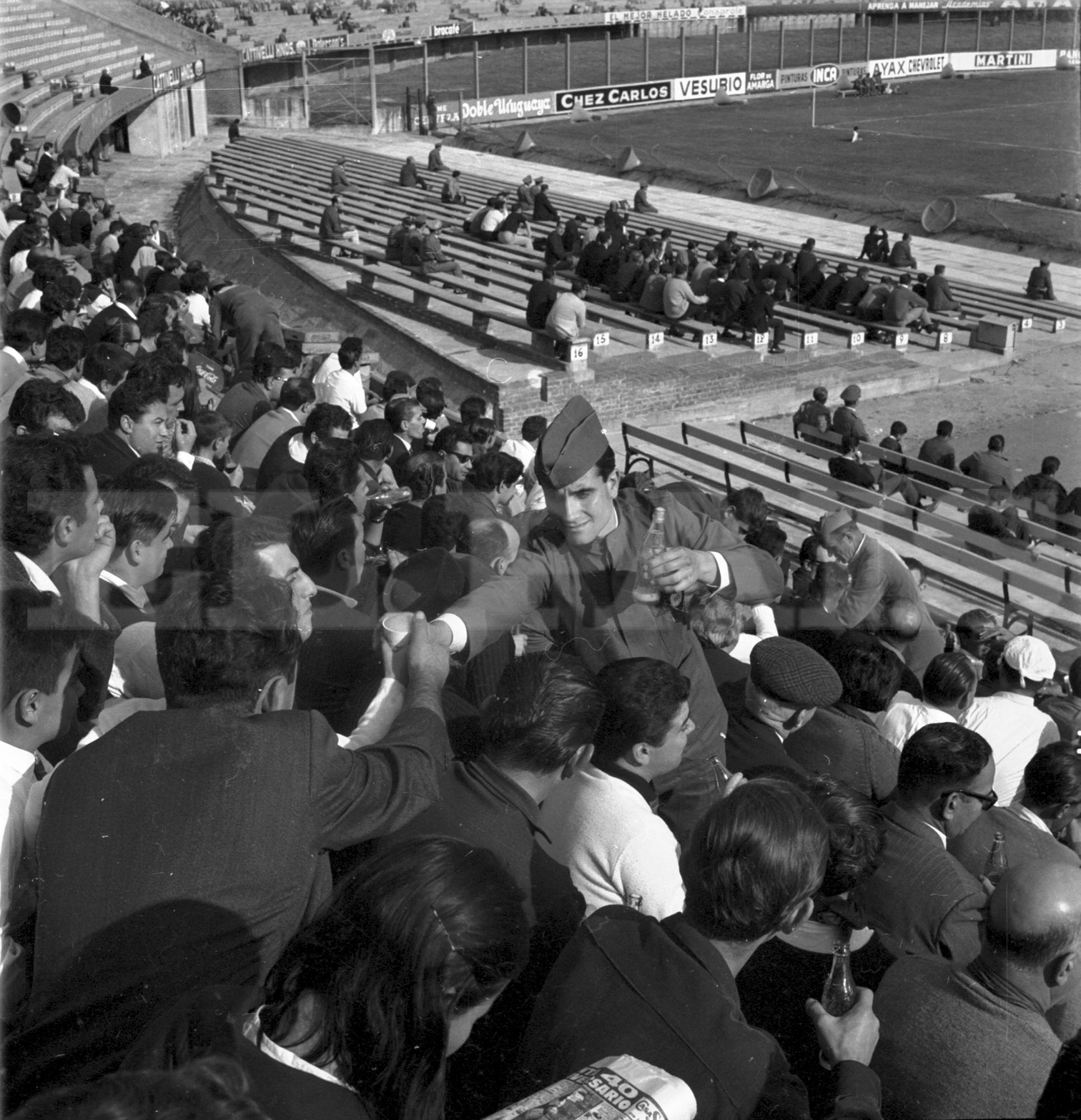 El “cocacolero” del Estadio Centenario. Uniformado, trabaja en la tribuna Olímpica. Al fondo, la vieja platea con bancos de madera. Foto: Archivo El País