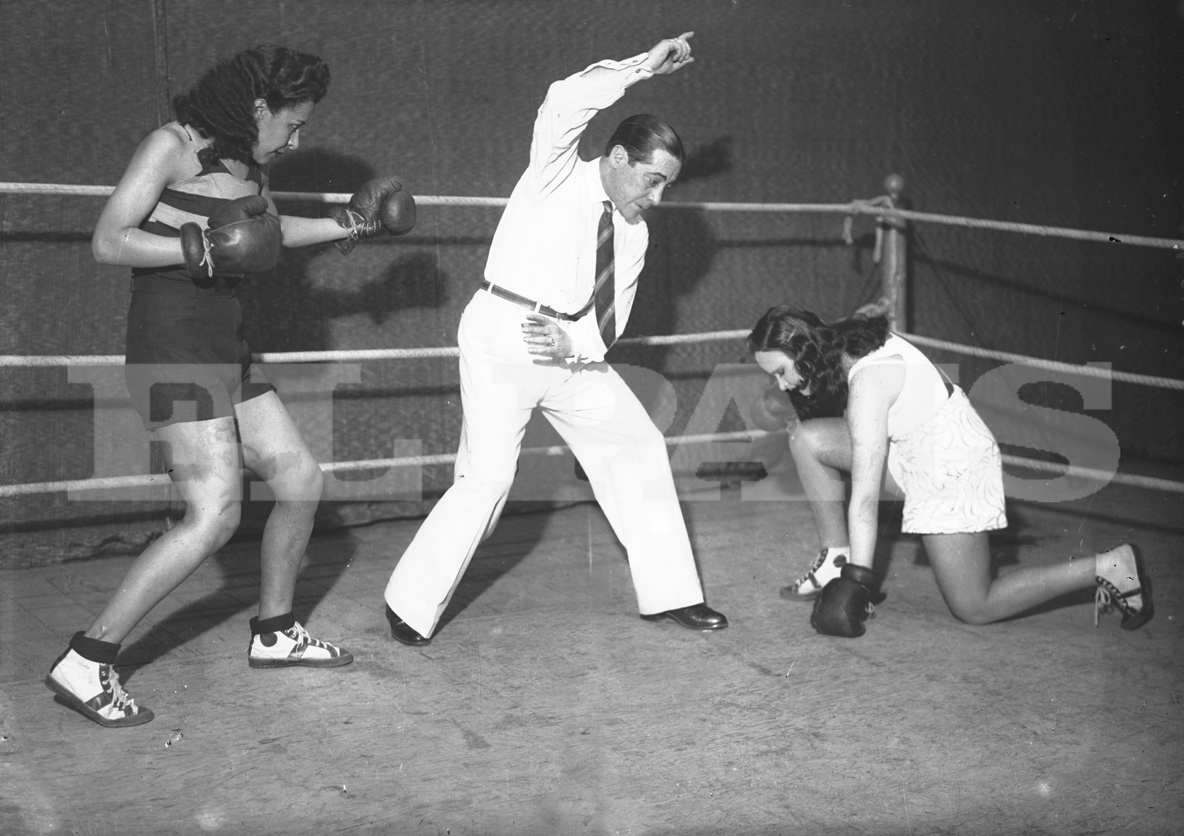 Una de las rivales en la lona mientras la otra mantiene su guardia. Pero no se trata de un combate de verdad, sino de una representación ante el fotógrafo. Foto: Archivo El País.