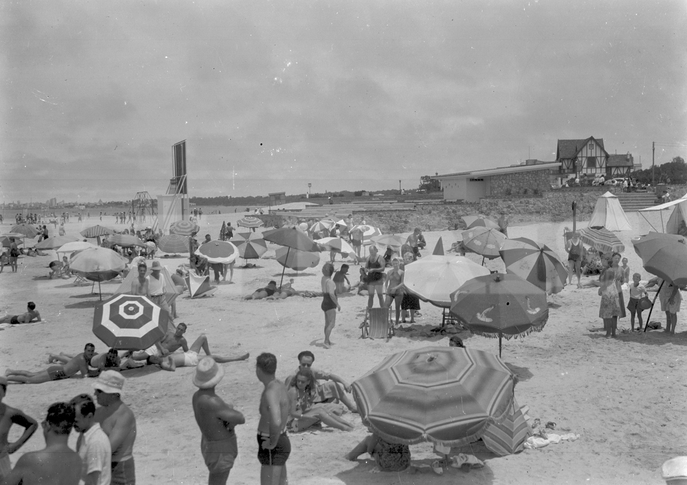 En plena playa Malvín funcionó durante años un cine al aire libre, cuya pantalla se eleva un poco sobre las sombrillas en la imagen. Foto: Archivo El País.