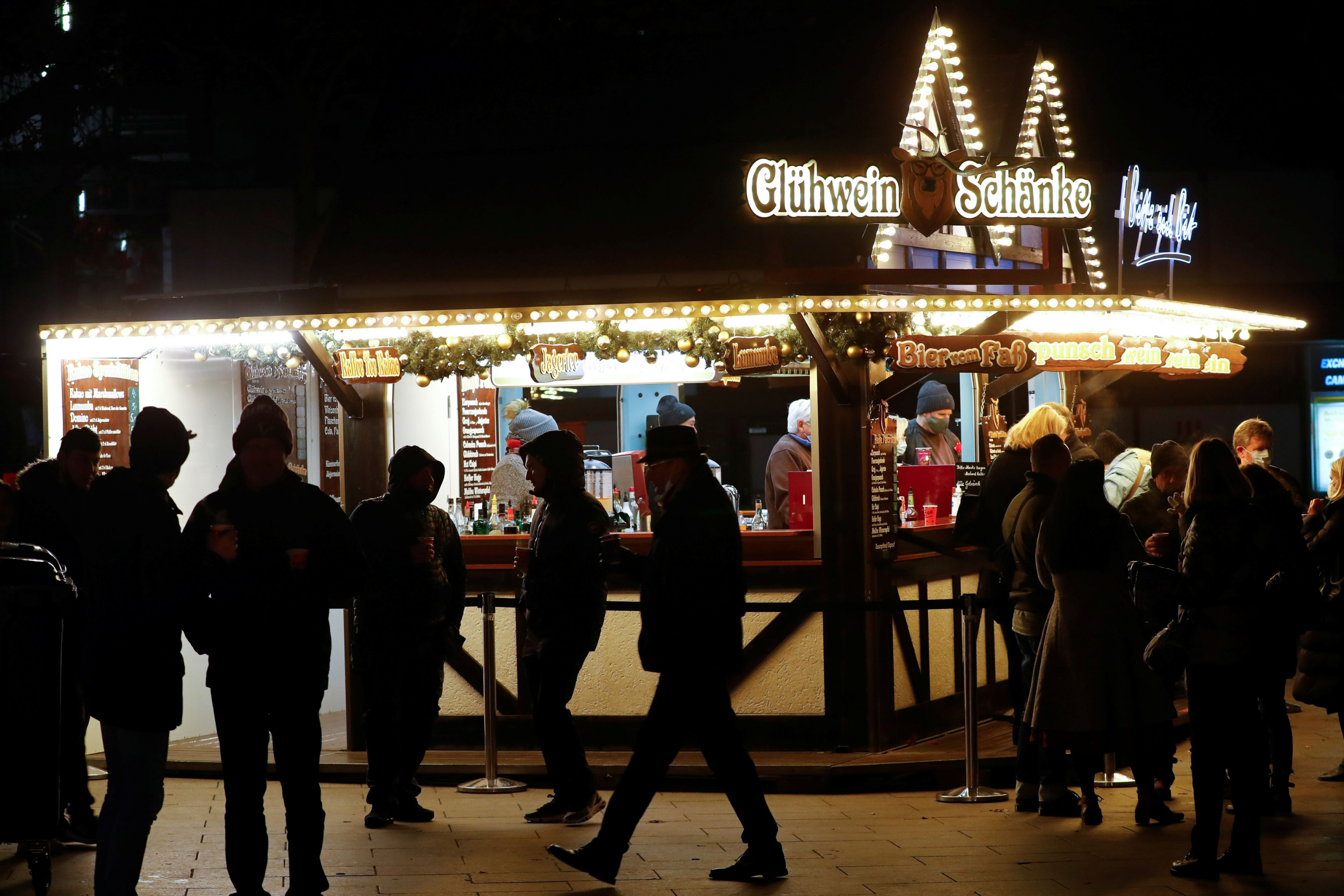 Personas alrededor de un puesto de vino caliente para llevar en un mercado navideño alemán en medio de la pandemia de COVID-19. Foto: Reuters