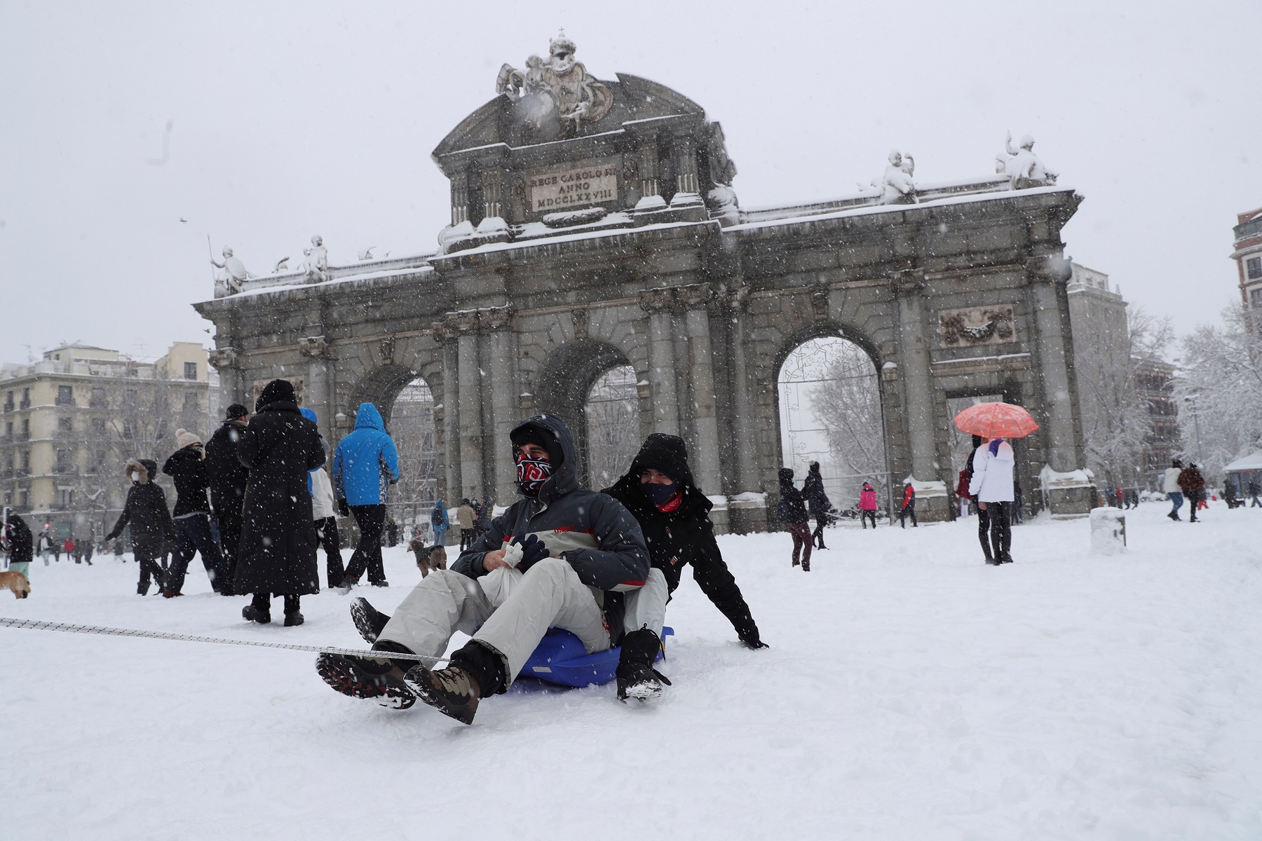 Una pareja se divierte en Madrid deslizándose por la nieve en un pequeño trineo. Foto: EFE