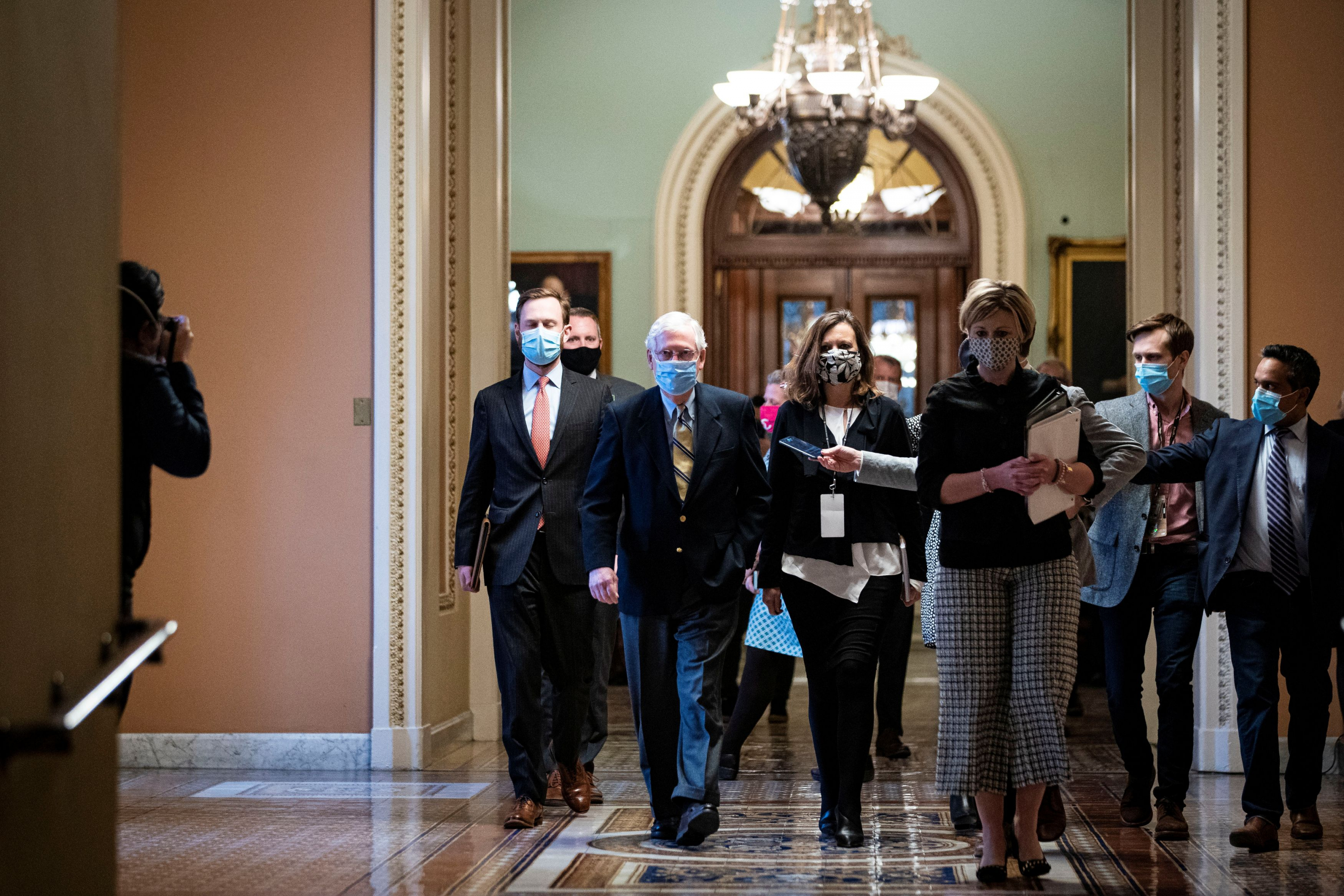 El líder de la minoría republicana, Mitch McConnell se retira junto con asesores. Foto: Reuters.