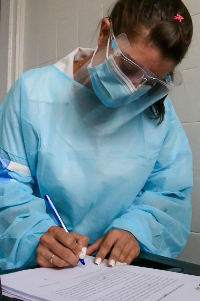 Funcionaria de la salud lee y firma el consentimiento previo a vacunarse. Foto: Estefanía Leal