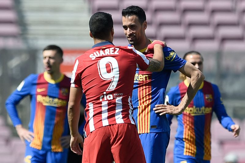 Luis Suárez y Sergio Busquets en el saludo previo al Barcelona-Atlético. Foto: AFP.