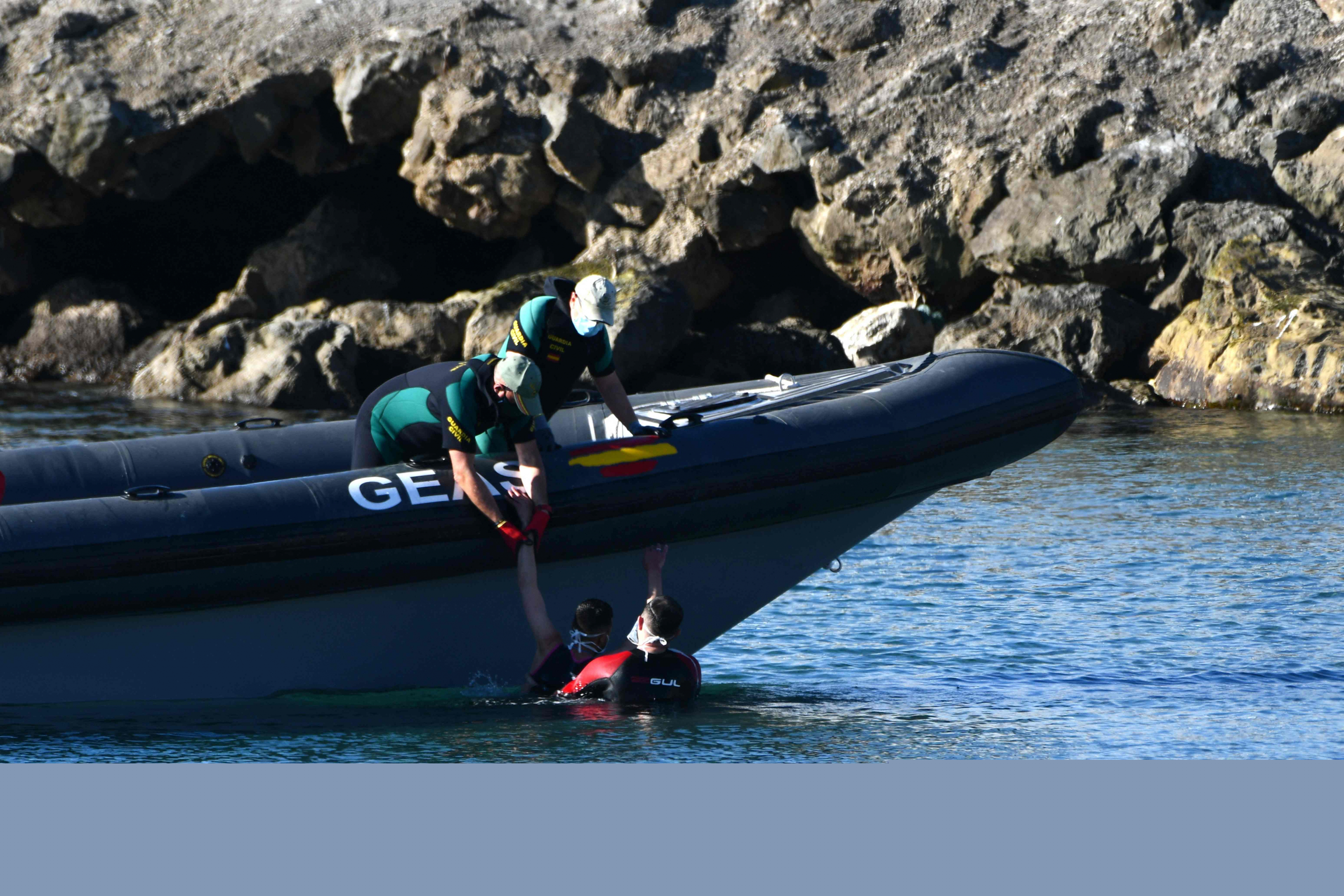 Guardias civiles españoles ayudan a una migrante después de que ella nadó hasta el enclave español de Ceuta. Foto: AFP