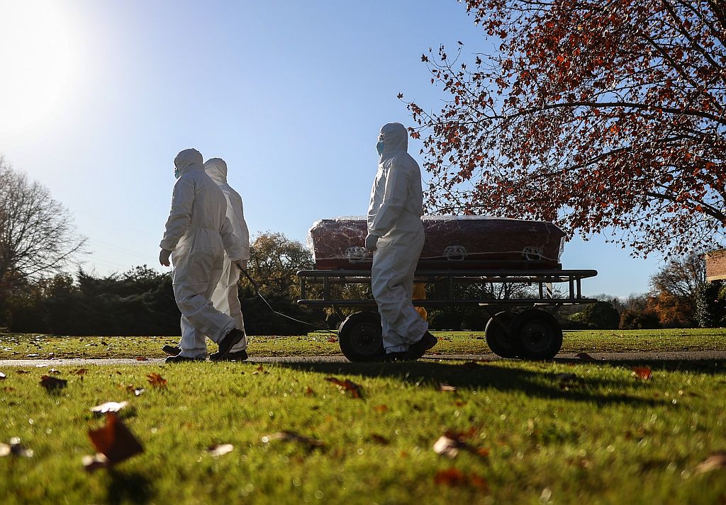 Funcionarios con trajes protectores llevan el féretro de un fallecido por coronavirus en Argentina. Foto: EFE