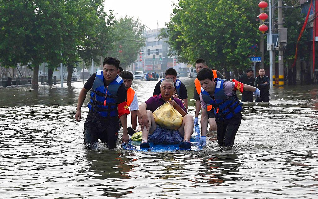 Socorristas ayudan a una víctima de las inundaciones en China. Foto: AFP
