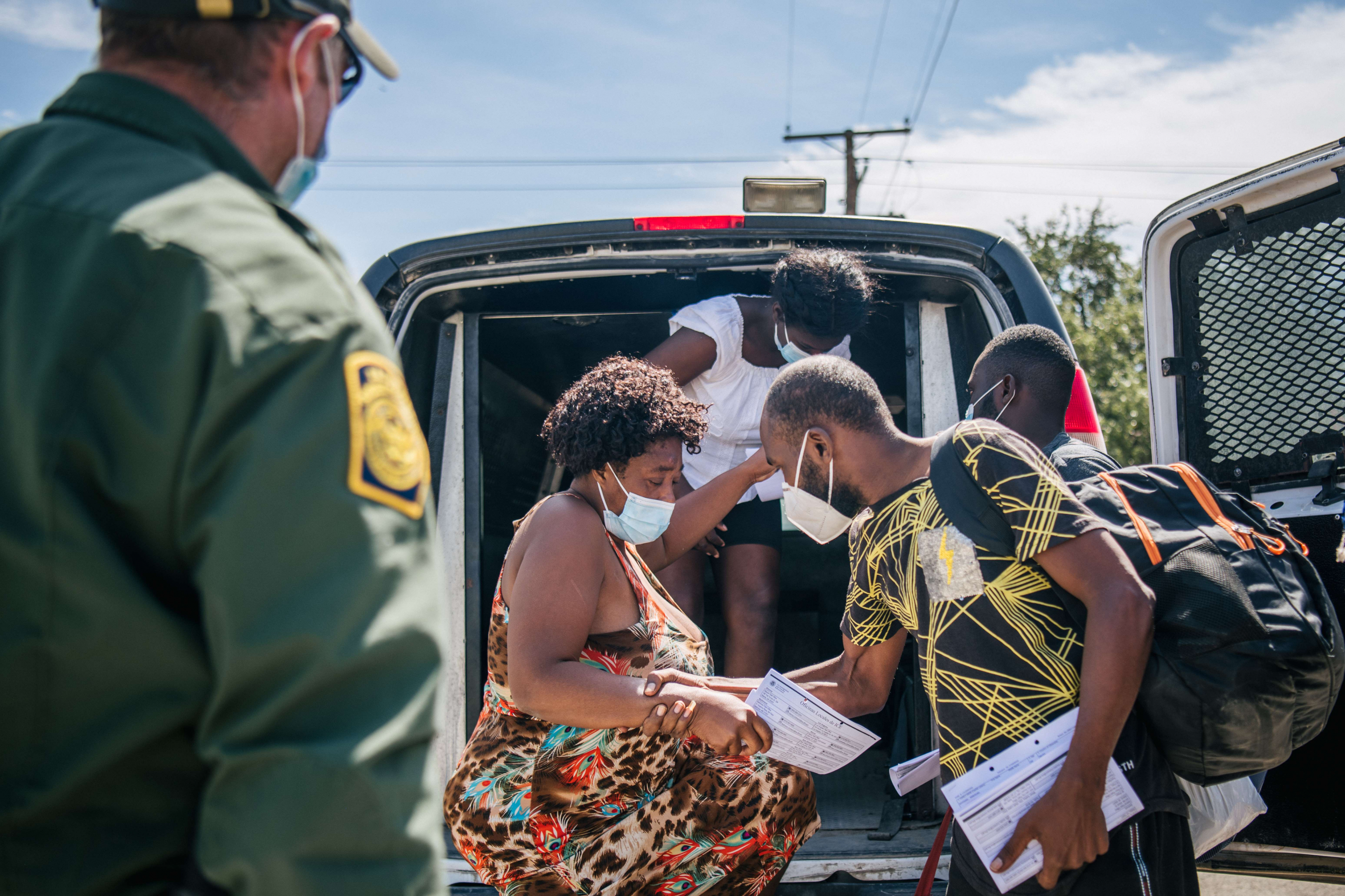 Migrantes salen de una camioneta de la Patrulla Fronteriza en Del Rio, Texas. Foto: AFP