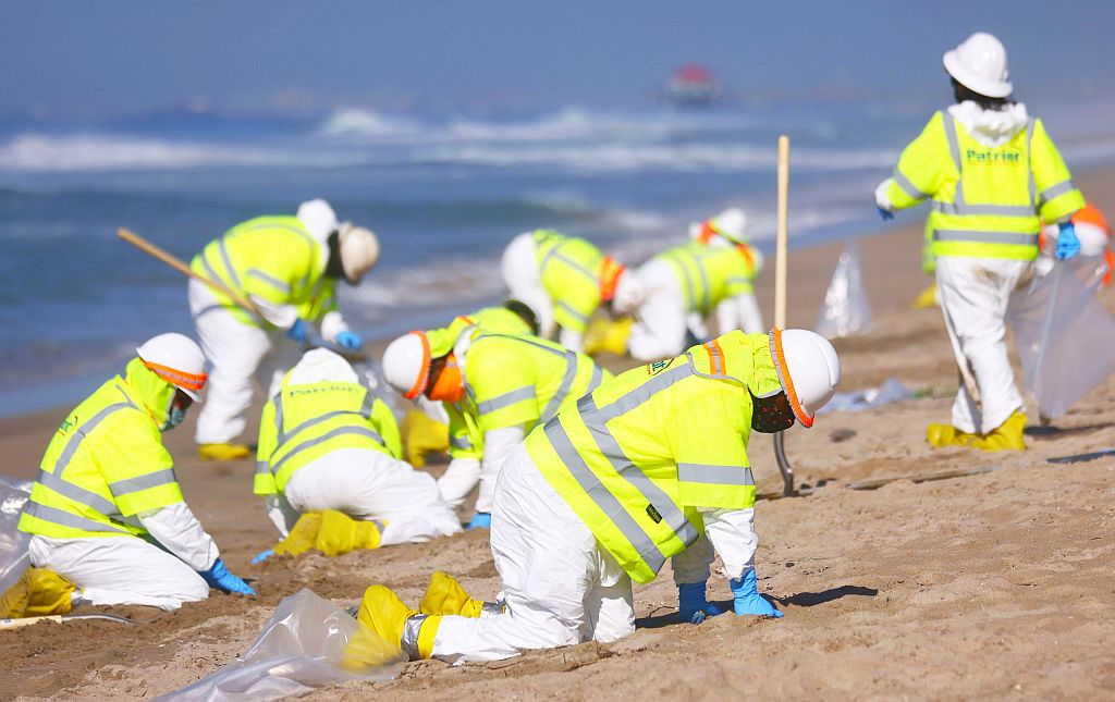 Funcionarios trabajan en la limpieza de las playas afectadas por el derrame de petróleo. Foto: AFP