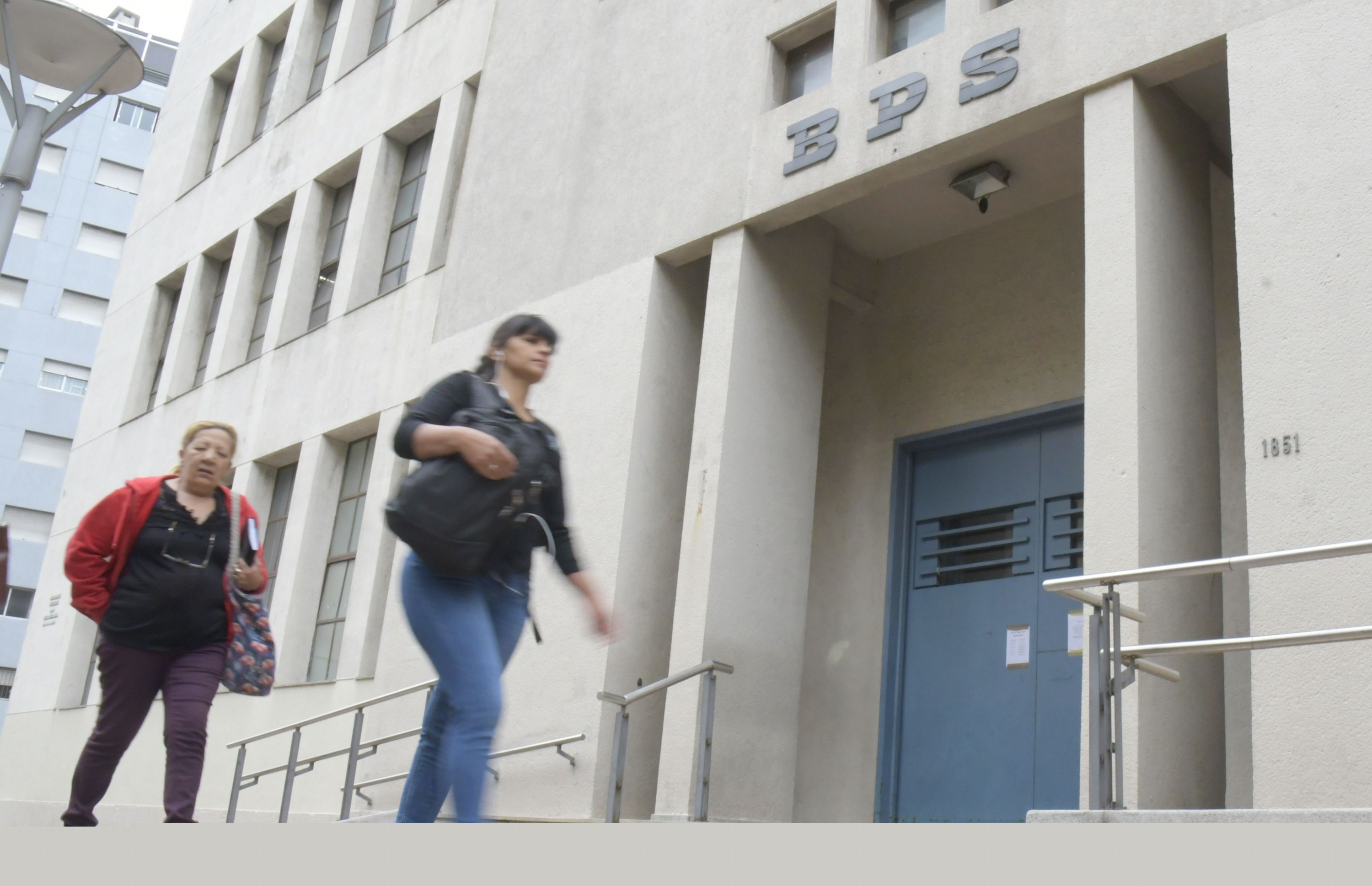 Dos mujeres pasan caminando frente a la sede del BPS. Foto: Darwin Borrelli (Archivo)