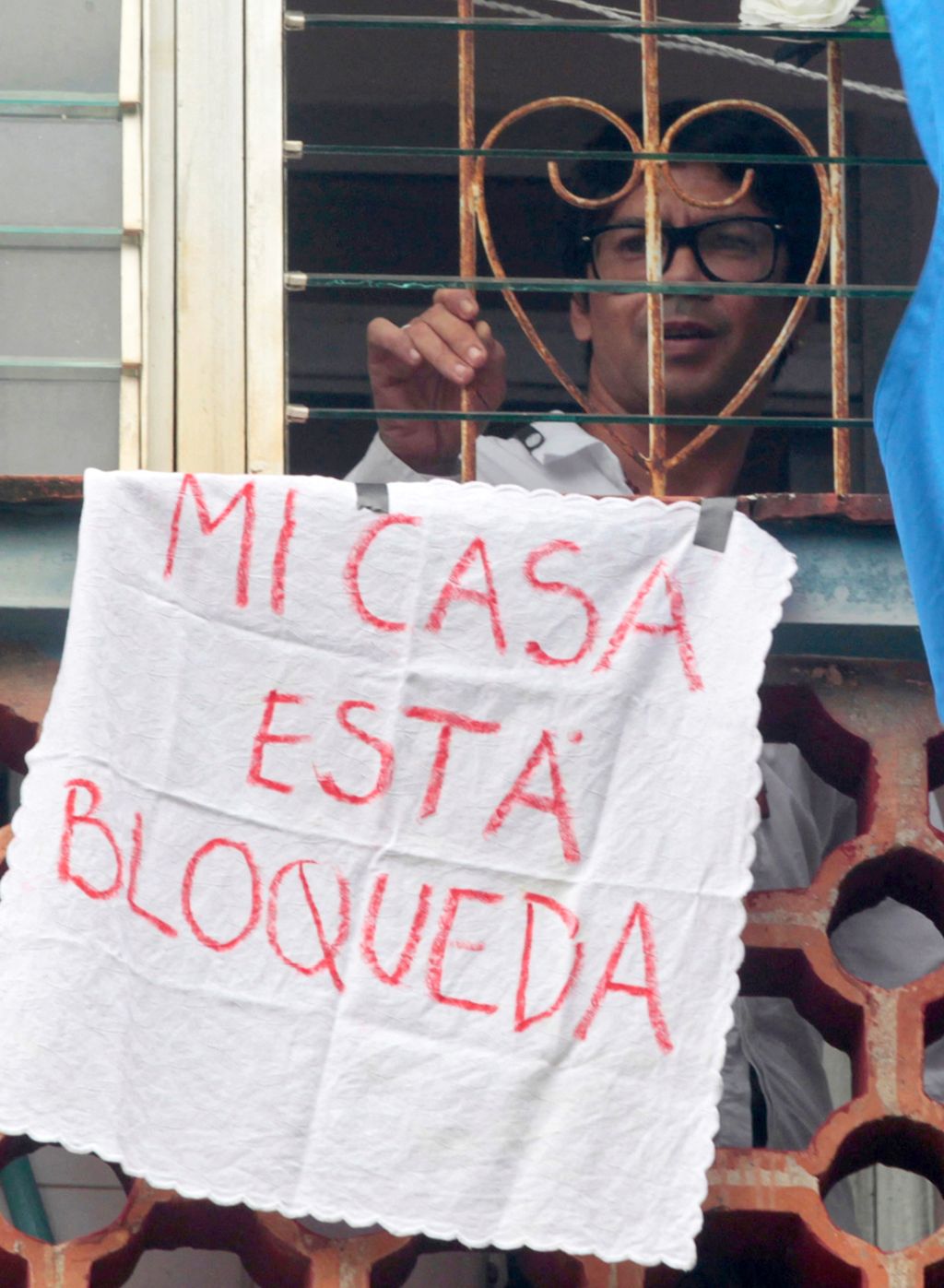 El dramaturgo Yunior García Aguilera protesta contra el régimen cubano desde la ventana de su casa. Foto: AFP