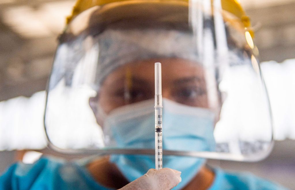 Funcionaria de la salud sostiene una vacuna contra el COVID-19. Foto: AFP