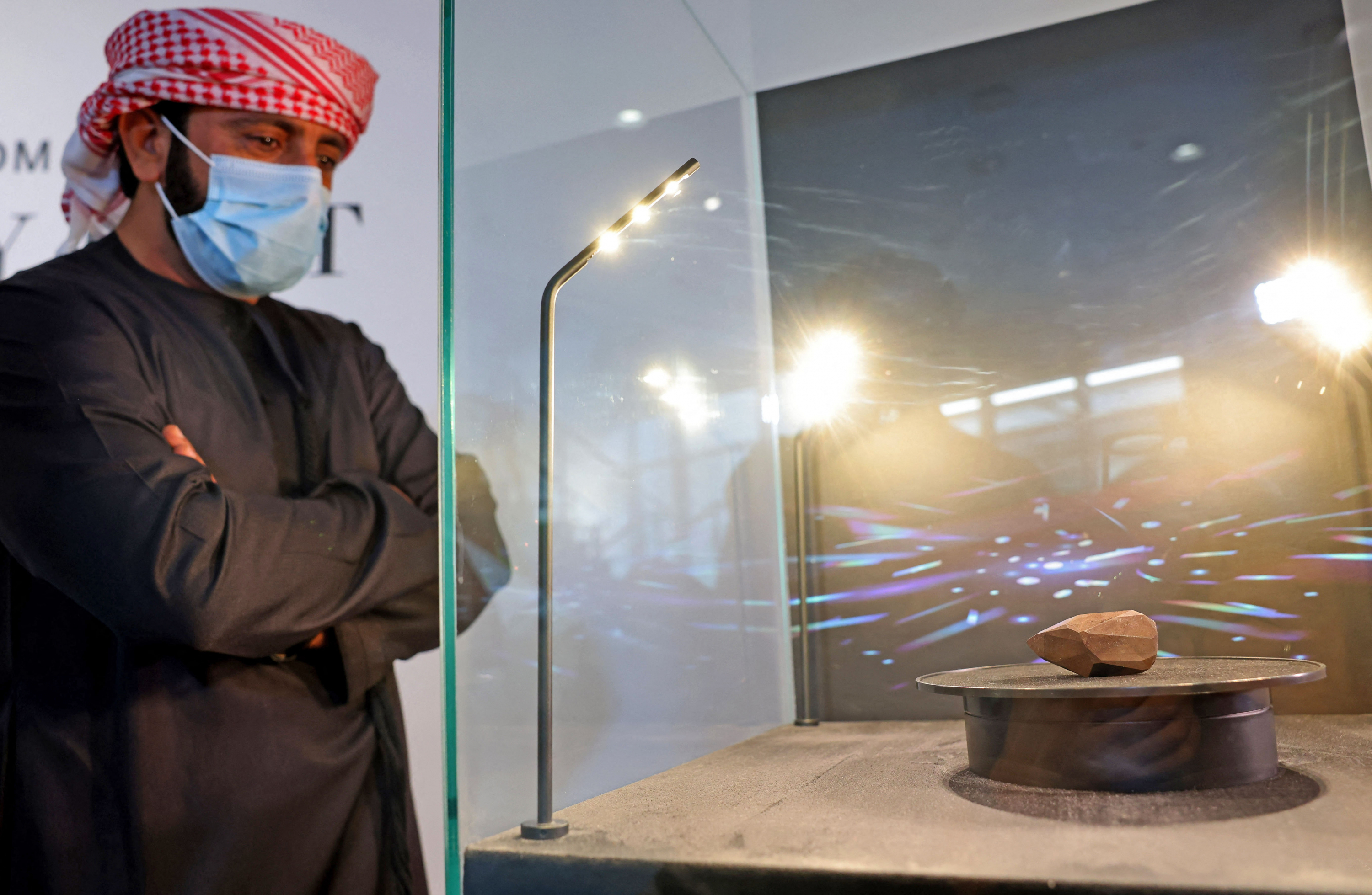 Hombre mirando el diamante negro que será subastado. Foto: AFP