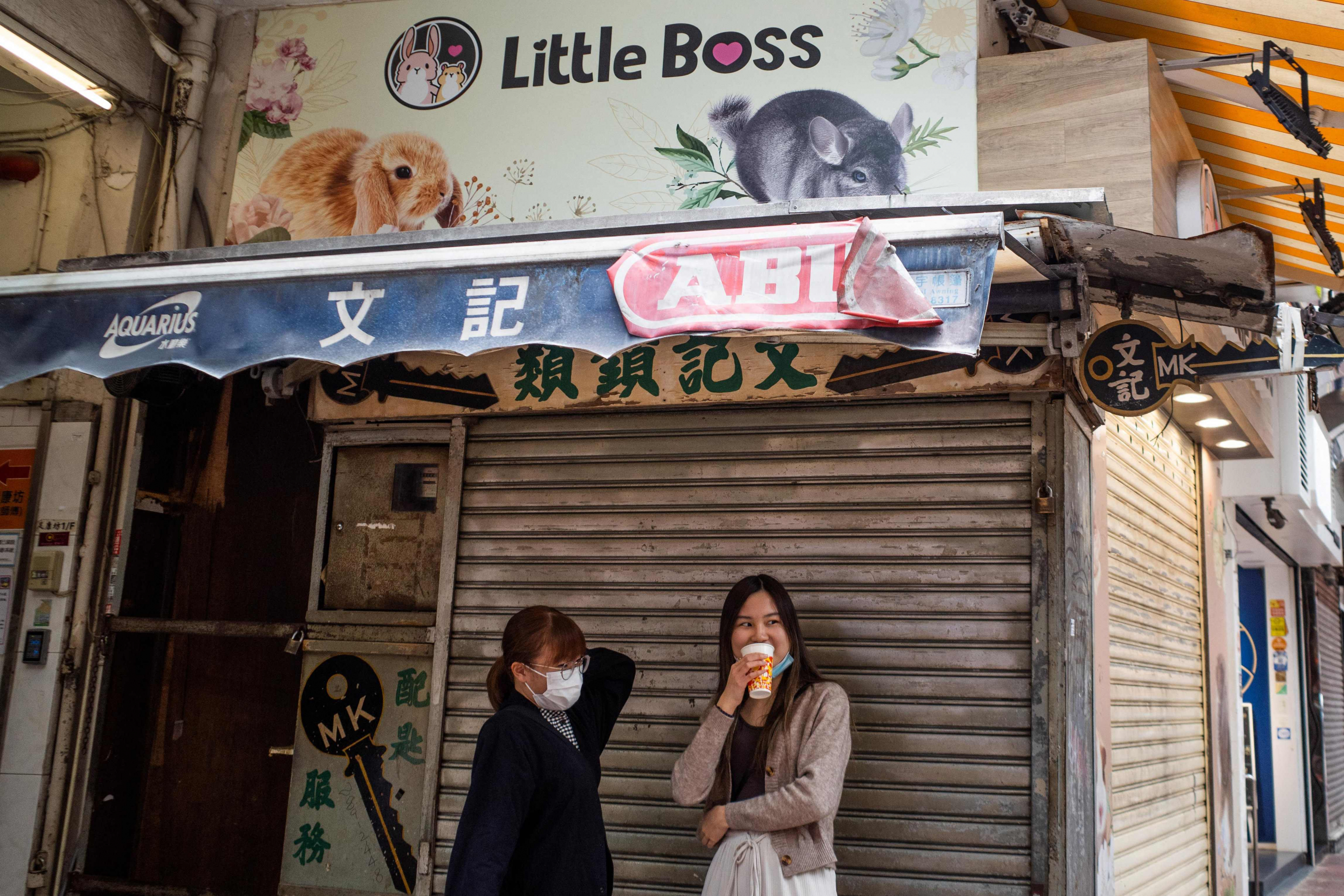 Personas paradas afuera de una veterinaria en Hong Kong donde un empleado y un cliente dieron positivo. Foto: AFP.