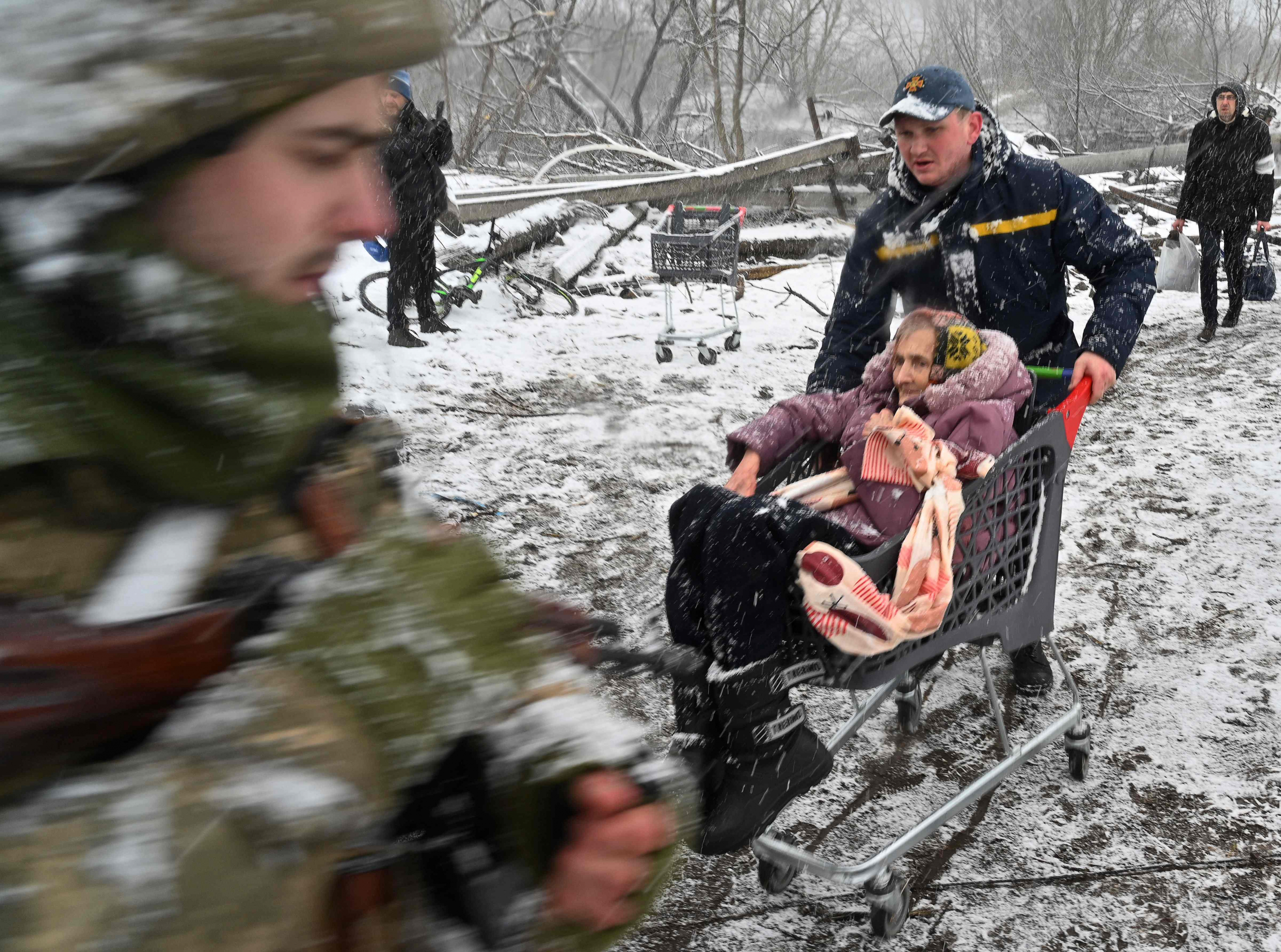 Un rescatista empuja un carro con una anciana durante la evacuación de civiles de la ciudad de Irpin, al noroeste de Kiev, este martes. Foto: AFP