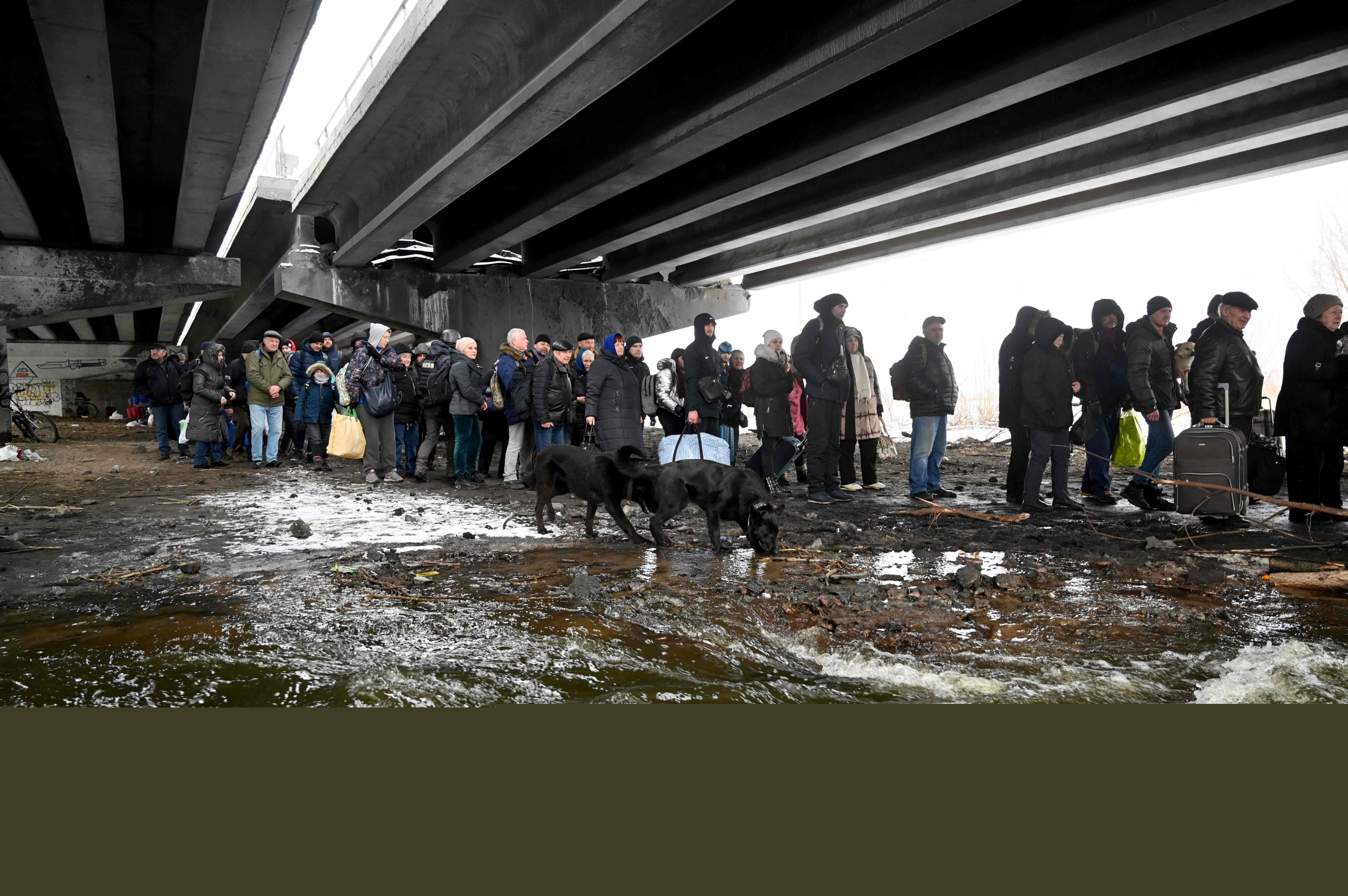 La gente hace cola para cruzar un puente destruido durante la evacuación de civiles de la ciudad de Irpin, al noroeste de Kiev, este martes. Foto: AFP